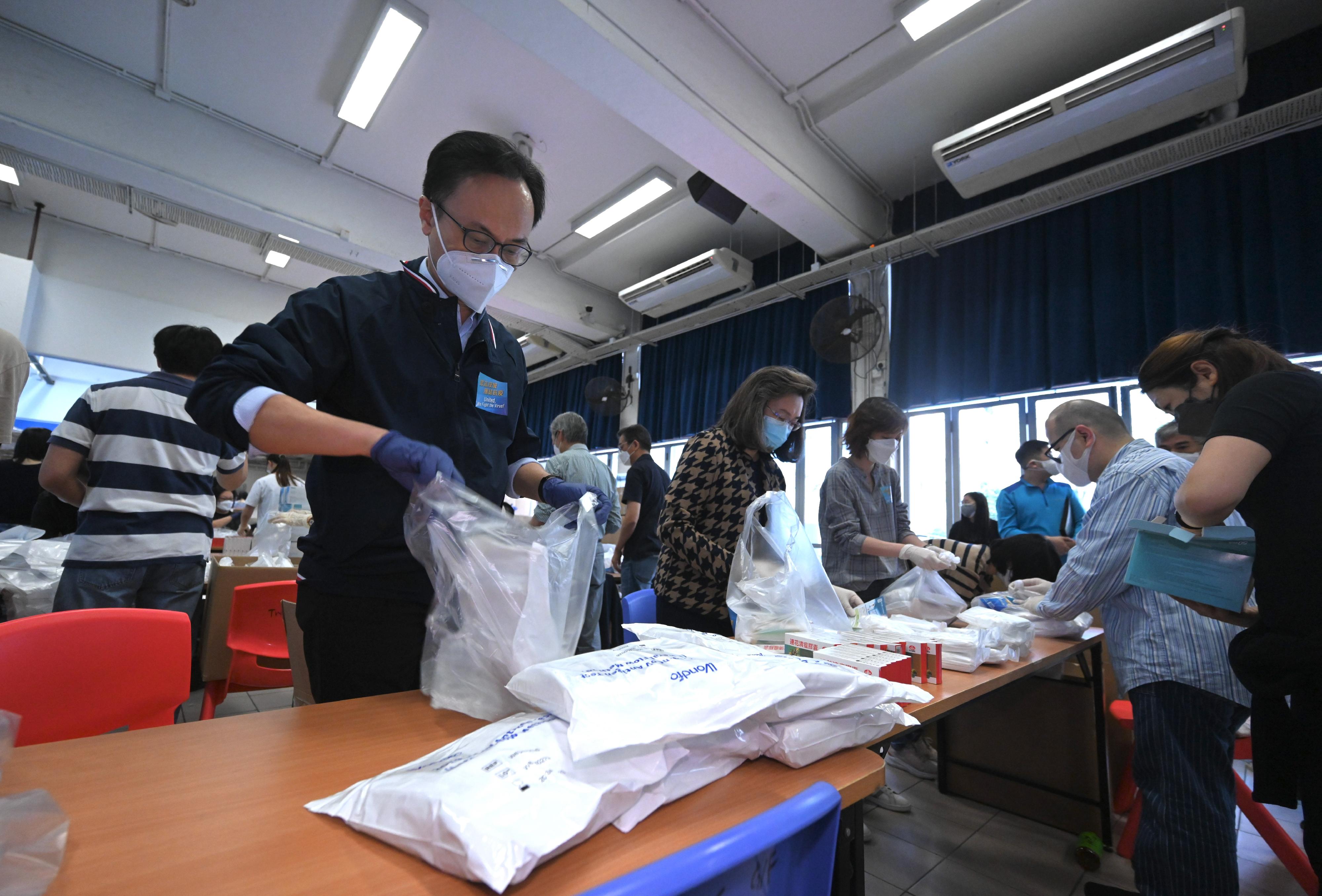 Led by the Permanent Secretary for the Civil Service, Mrs Ingrid Yeung, around 260 civil servants from the Civil Service Bureau (CSB) are gathering at Tsuen Wan Catholic Primary School to participate in the packaging of anti-epidemic service bags together today and tomorrow (March 30 and 31), in the hope that the anti-epidemic supplies will be distributed to the public as soon as possible and as a united effort to fight the epidemic. Colleagues taking part in the packaging work come from different posts of the CSB, including officers from the Administrative Officer Grade, the Executive Officer Grade, the Official Languages Officer Grade, the Analyst Programmer Grade and the Clerical and Secretarial Grades, etc. Over 10 retired Administrative Officers at directorate level also participated voluntarily and helped with the packaging of the anti-epidemic service bags together. Photo shows the Secretary for the Civil Service, Mr Patrick Nip (first left), packaging the anti-epidemic service bags with Mrs Yeung (second left) and other colleagues during his visit to the school to show support for colleagues. 