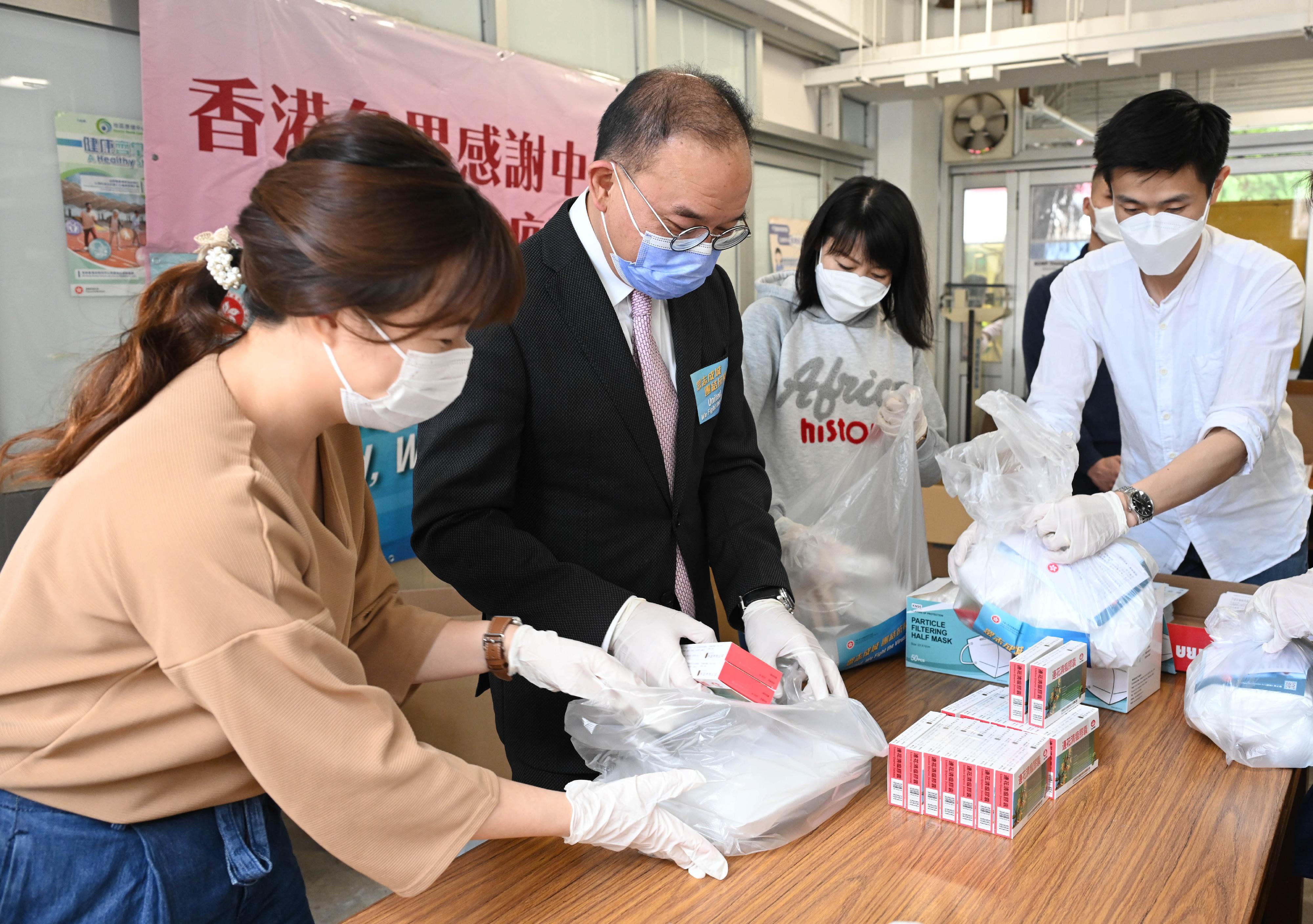 The Secretary for Constitutional and Mainland Affairs, Mr Erick Tsang Kwok-wai (second left), today (March 30) visited the anti-epidemic service bag packaging centre located at Ho Lap College (sponsored by Sik Sik Yuen) in Wong Tai Sin to show his support for colleagues and participate in the packaging work.