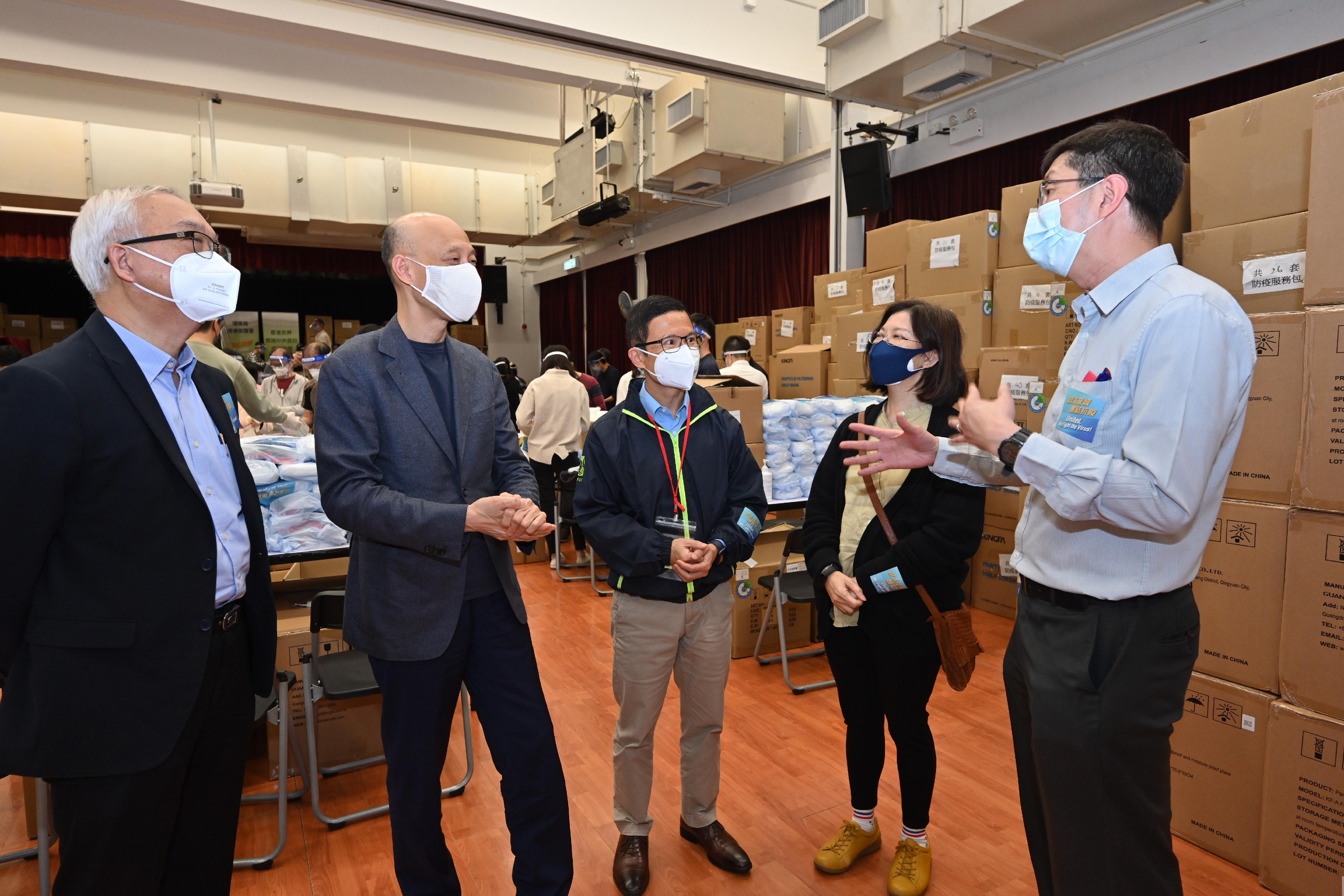 The Secretary for the Environment, Mr Wong Kam-sing, today (March 30) visits the Kwai Fong Community Hall to participate in the packing of anti-epidemic service bag and show support to the Environmental Protection Department (EPD) staff at the packing centre. Picture shows Mr Wong (second left); the Permanent Secretary for the Environment/Director of Environmental Protection, Miss Janice Tse (second right); the Under Secretary for the Environment, Mr Tse Chin-wan (first left); and the District Officer (Kwai Tsing), Mr Kenneth Cheng (centre), receiving a briefing on the operation of the packing centre at Kwai Fong Community Hall from a staff of the EPD.
