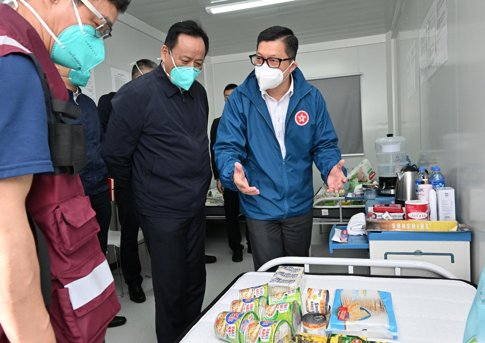 The expert group led by the Leader of the Mainland Chinese medicine expert group of the Central Authorities, Mr Tong Xiaolin, today (March 30) visited the community isolation facility in Hung Shui Kiu, Yuen Long. Photo shows the Secretary for Security, Mr Tang Ping-keung (first right) introducing the supplies in the community isolation facility to Mr Tong (second left) and the expert group.