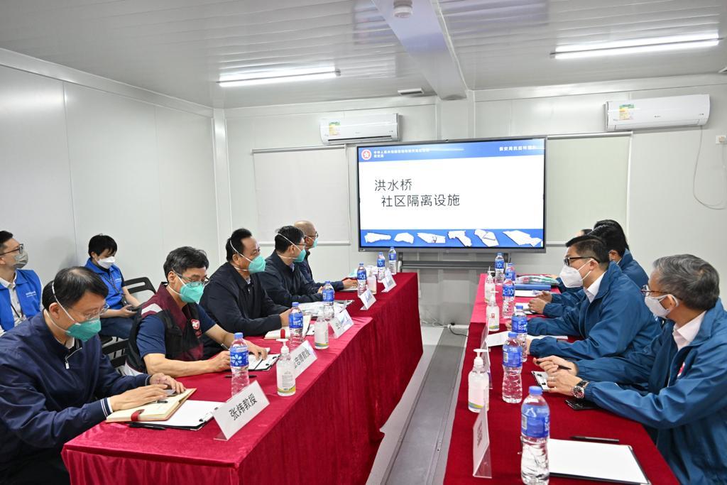 The expert group led by the Leader of the Mainland Chinese medicine expert group of the Central Authorities, Mr Tong Xiaolin, today (March 30) visited the community isolation facility in Hung Shui Kiu, Yuen Long. Photo shows the Secretary for Security, Mr Tang Ping-keung (second right) briefing Mr Tong (fifth left) and the expert group on the work of facility management.
