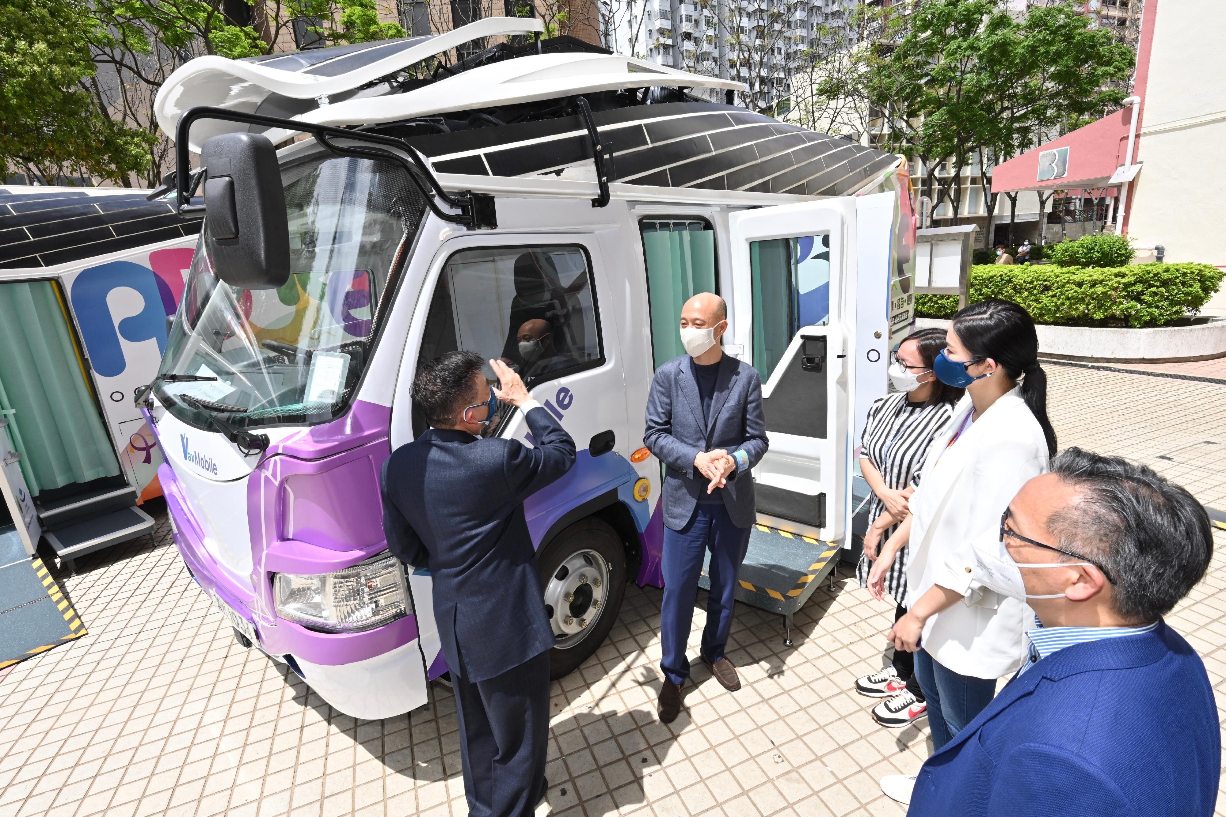 The Secretary for the Environment, Mr Wong Kam-sing, today (March 31) visited Tsui Ping Estate, Kwun Tong, to view the COVID-19 Mobile Vaccination Station (Station No. 4) which operates in the form of an electric vaccination vehicle. The electric vehicle adopts a pure electric design with solar photovoltaic panels installed on the rooftop, balancing efficiency and environmental protection needs. It does not emit exhaust gas when operating along the roadside and will not affect the air quality even if the vehicle keeps running or idles for long hours during operation. Picture shows Mr Wong (second left) being briefed on the design of the electric vehicle.