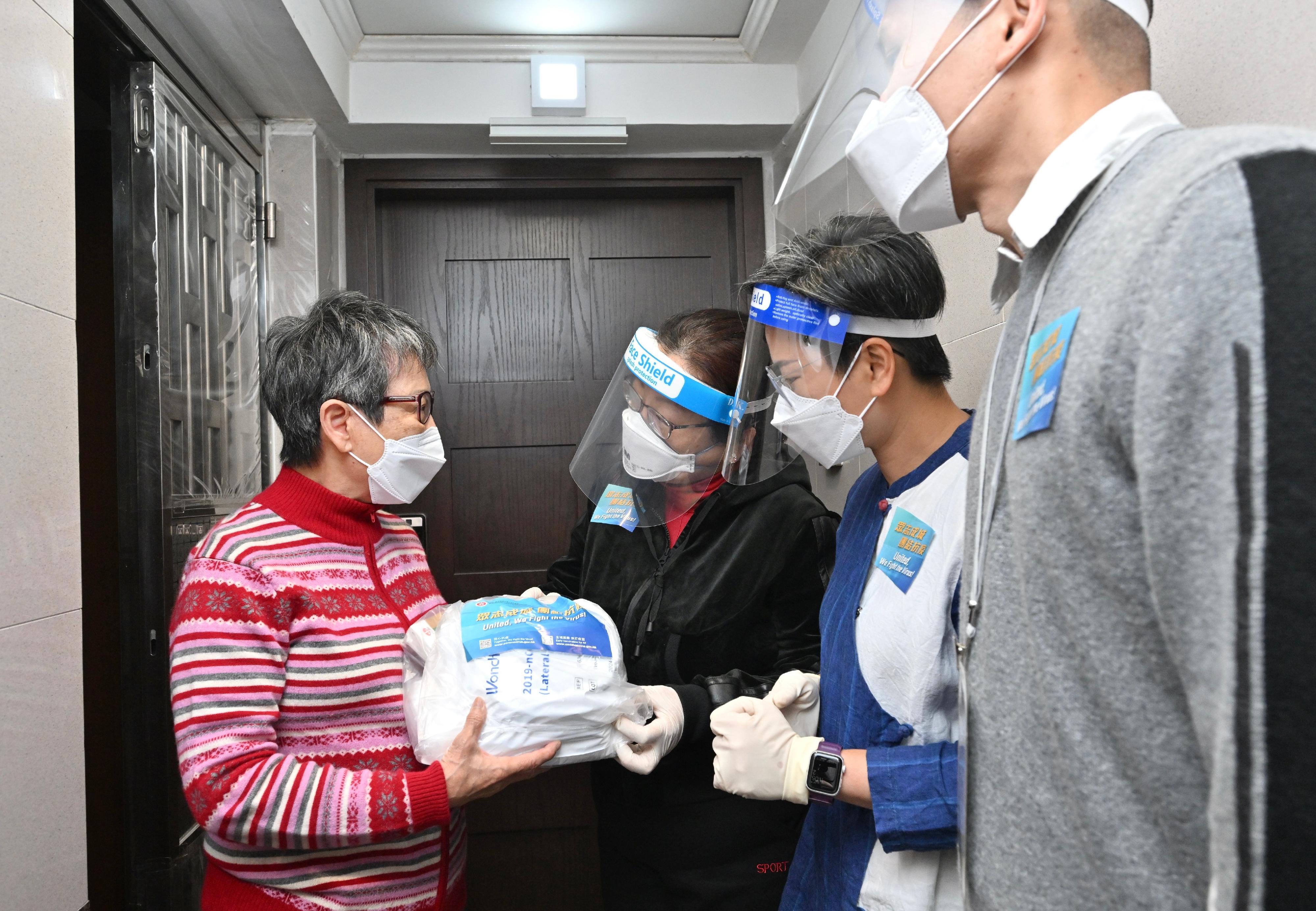 The Secretary for Justice, Ms Teresa Cheng, SC, distributed anti-epidemic service bags to households in San Po Kong today (April 2) and visited a single elderly person and an ethnic minority family to learn more about their living conditions and challenges they faced under the epidemic. Photo shows Ms Cheng (third right) distributing an anti-epidemic service bag to a single elderly person. Also present are the District Officer (Wong Tai Sin), Mr Steve Wong (first right), and the secretary of the East Kowloon District Residents' Committee, Ms Wendy Lui (second right).