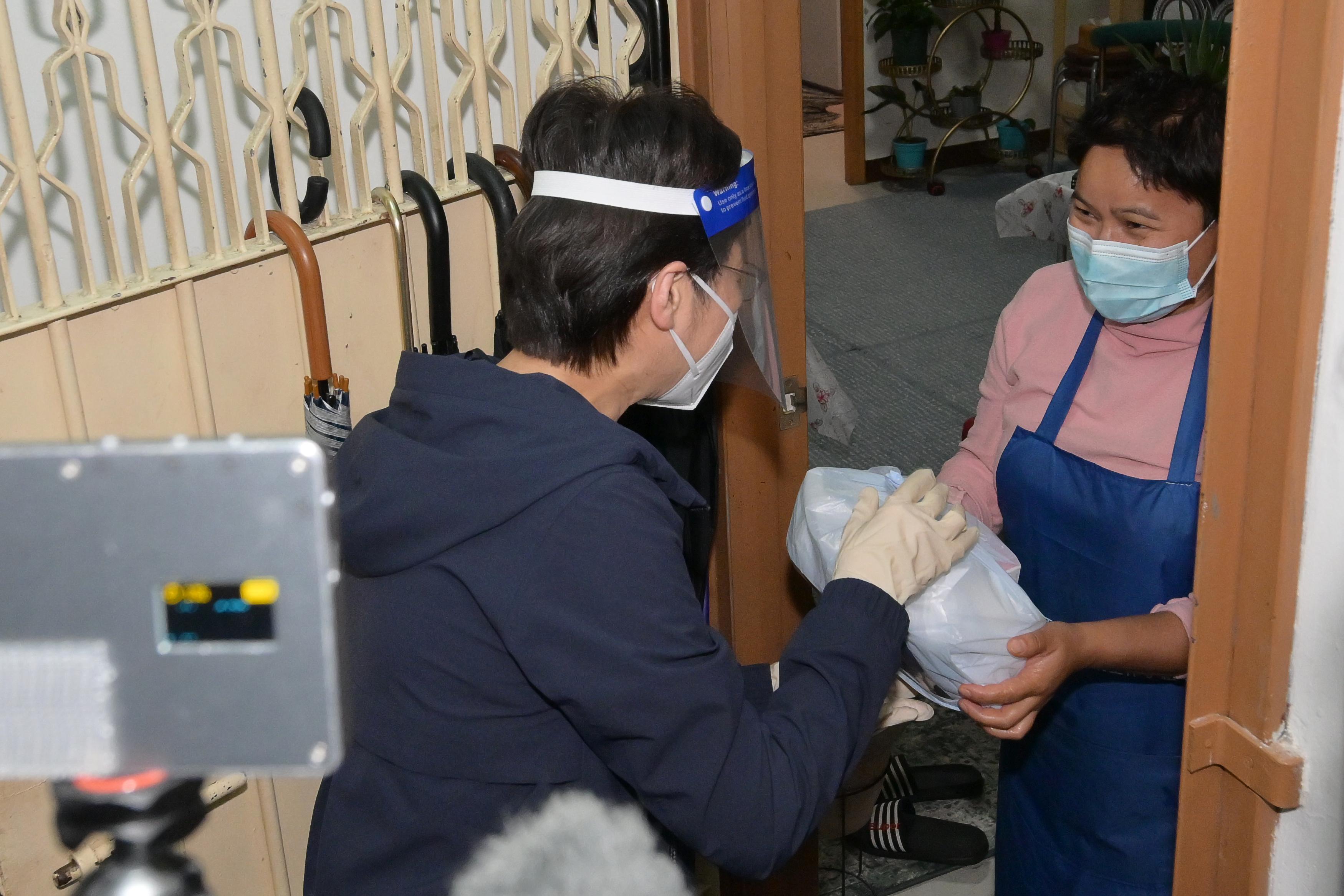 The Chief Executive, Mrs Carrie Lam, today (April 2), took part in the territory-wide distribution of anti-epidemic service bags. Photo shows Mrs Lam (left) visiting a "three-nil" private building in Central and Western District to distribute anti-epidemic service bags door to door.