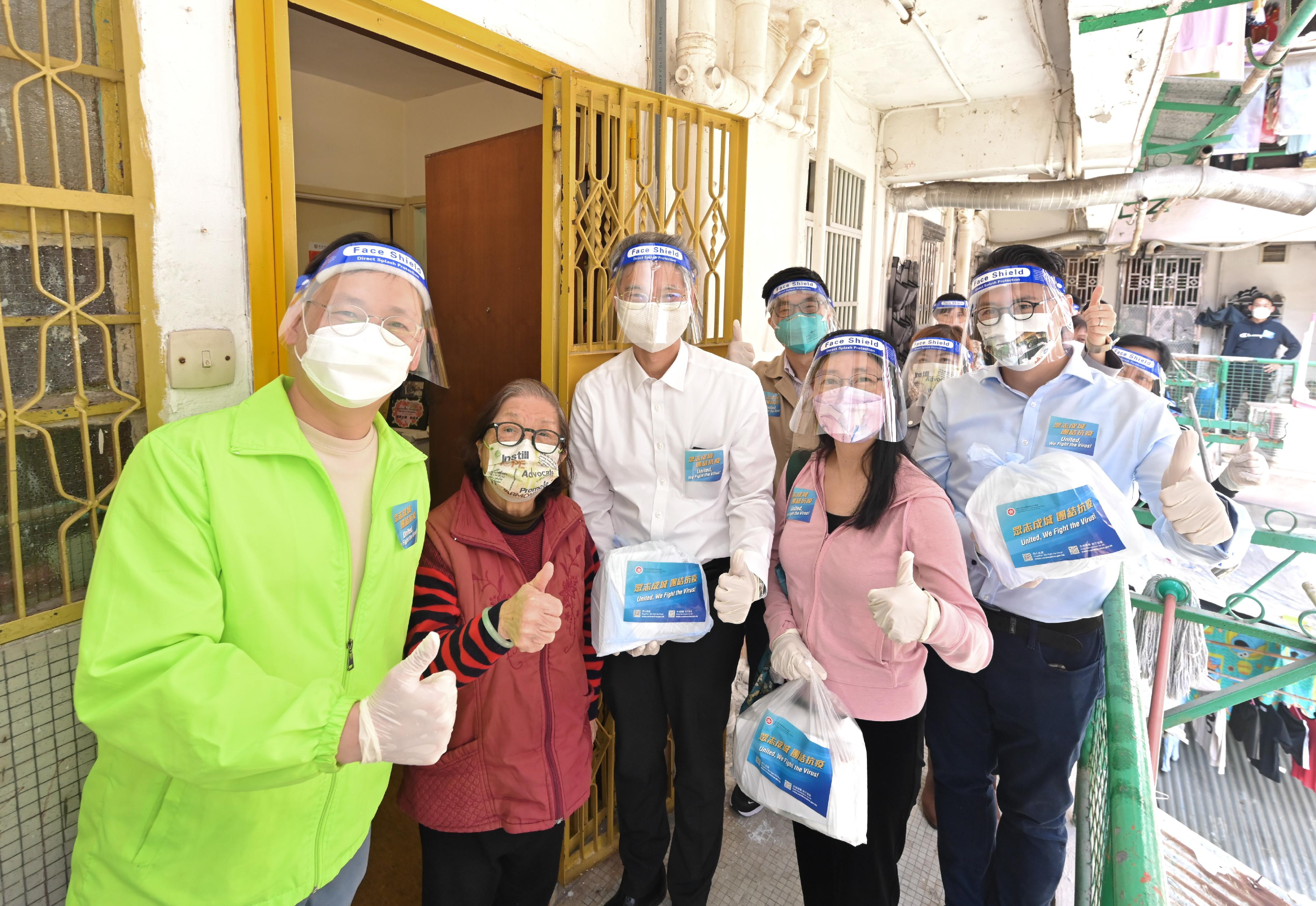 The Secretary for Labour and Welfare, Dr Law Chi-kwong, and the Permanent Secretary for Labour and Welfare, Ms Alice Lau, today (April 4) led their team to distribute anti-epidemic service bags to households in an old building in Kwun Tong District. Photo shows Dr Law (front row, centre); Ms Lau (front row, second right); the Chairman of Kwun Tong District Council, Mr Wilson Or (front row, first left); and the District Officer (Kwun Tong), Mr Steve Tse (front row, first right), delivering a service bag to an elderly singleton.