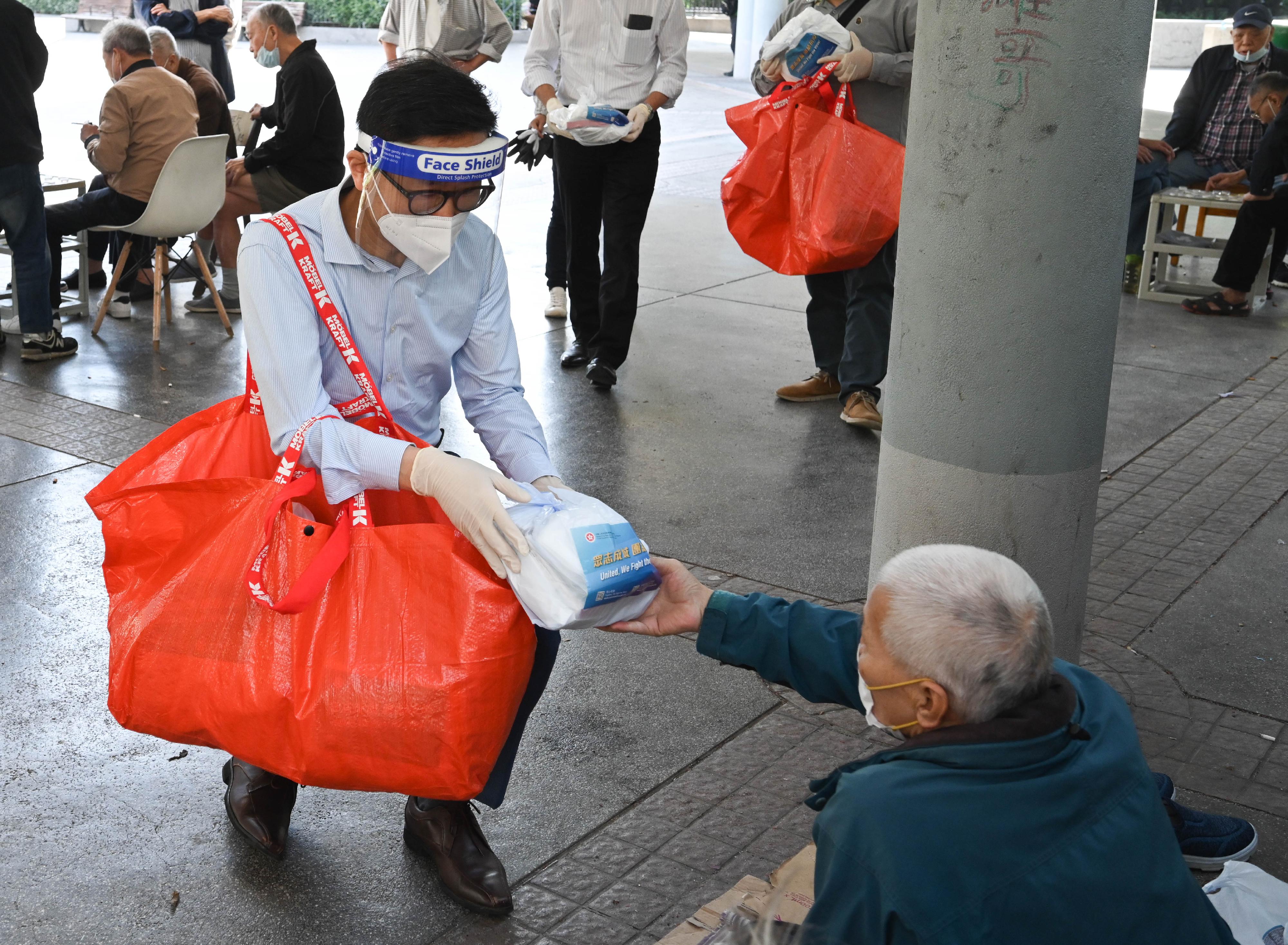 The Sham Shui Po District Office and the Yau Tsim Mong District Office, together with non-governmental organisations, distributed anti-epidemic service bags to street sleepers on April 4. Picture shows the District Officer (Sham Shui Po), Mr Paul Wong, distributing an anit-epidemic service bag to a street sleeper.
