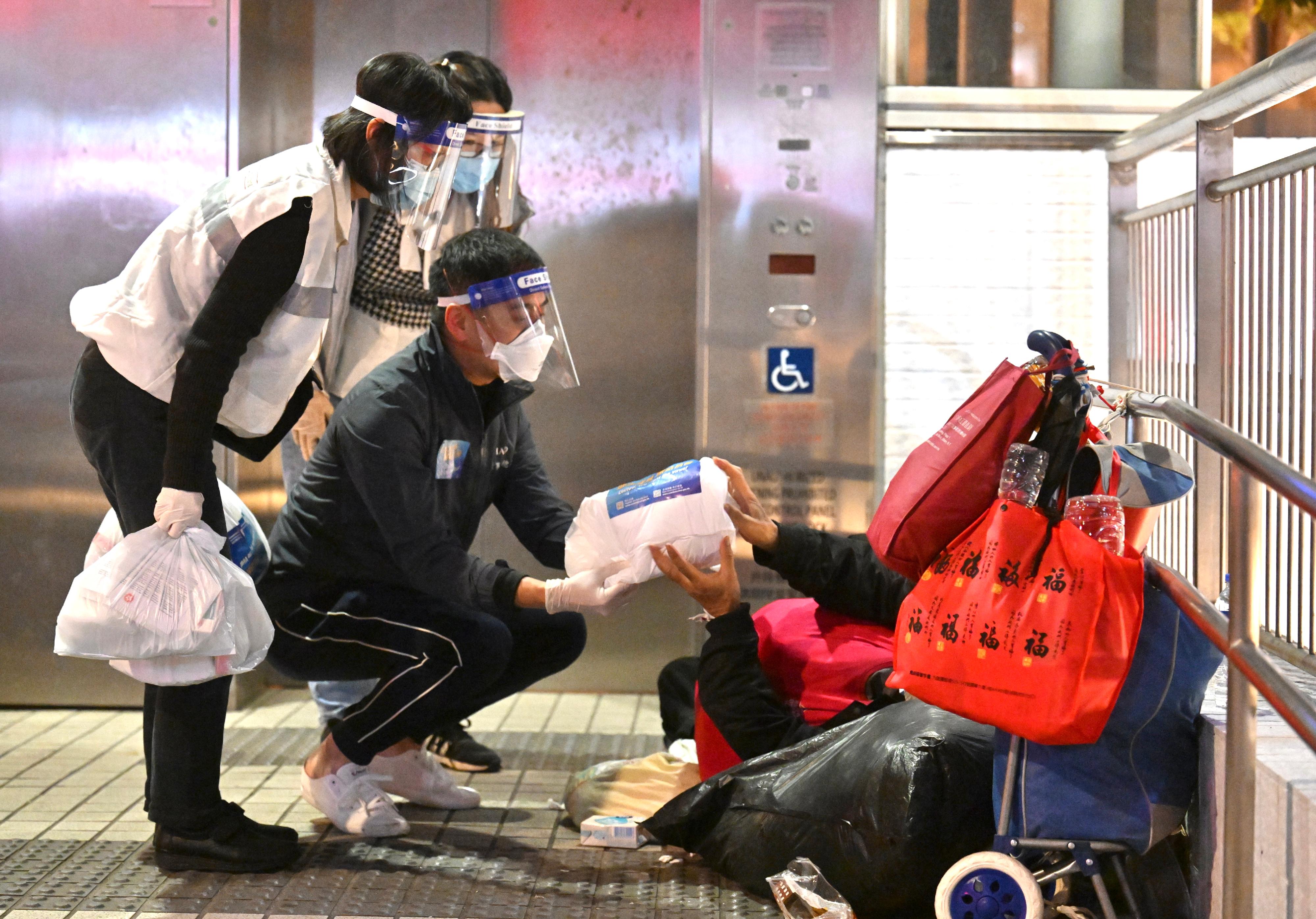The Sham Shui Po District Office and the Yau Tsim Mong District Office, together with non-governmental organisations, distributed anti-epidemic service bags to street sleepers on April 4. Picture shows the District Officer (Yau Tsim Mong), Mr Edward Yu, distributing an anit-epidemic service bag to a street sleeper.