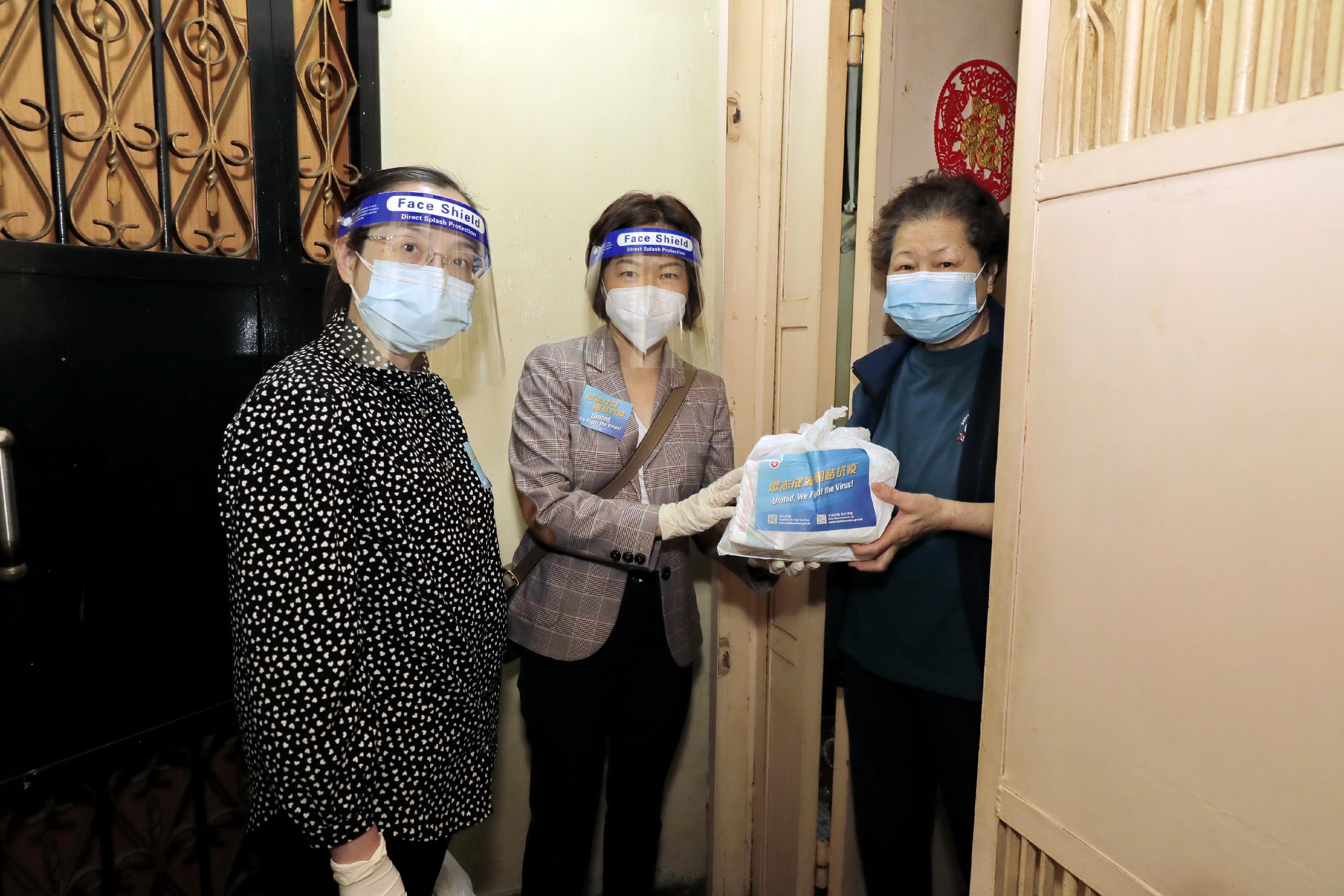 The new Director of Home Affairs, Mrs Alice Cheung, together with volunteer groups today (April 6) distributed anti-epidemic service bags to grassroots families in an old building in Yau Ma Tei. Photo shows Mrs Cheung (centre) and the Deputy Director of Home Affairs, Miss Vega Wong (left), distributing an anti-epidemic service bag door-to-door to a resident living in the old building.