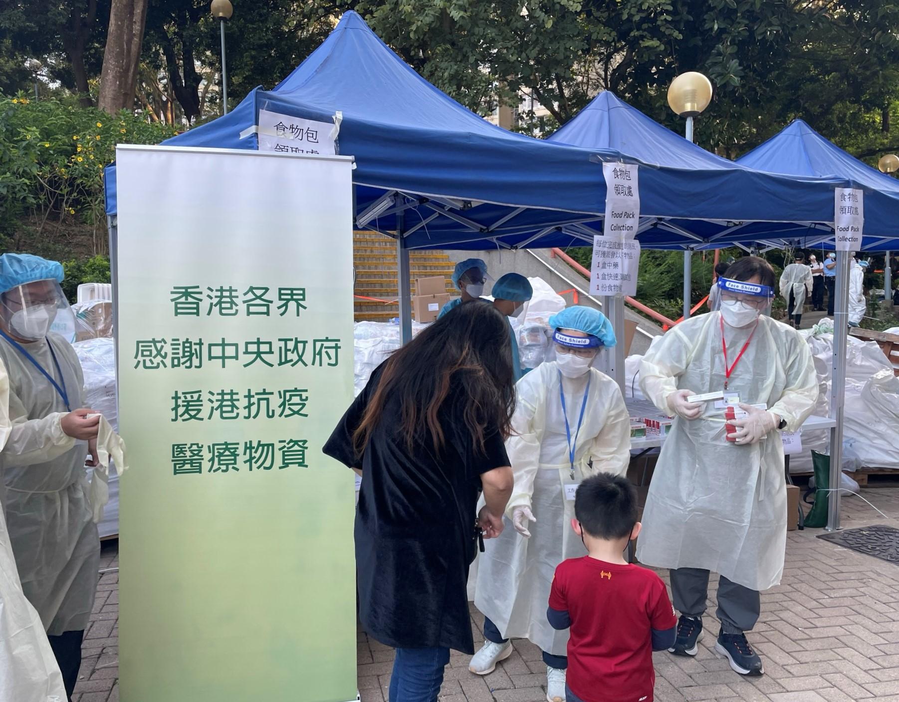 The Government yesterday (April 9) enforced "restriction-testing declaration" and compulsory testing notice in respect of specified "restricted area" in Hin Yau House, Hin Keng Estate, Sha Tin. Photo shows staff members of the Agriculture, Fisheries and Conservation Department distributing food packs, rapid antigen test kits and anti-epidemic proprietary Chinese medicines supplied by the Central Government to residents subject to compulsory testing.