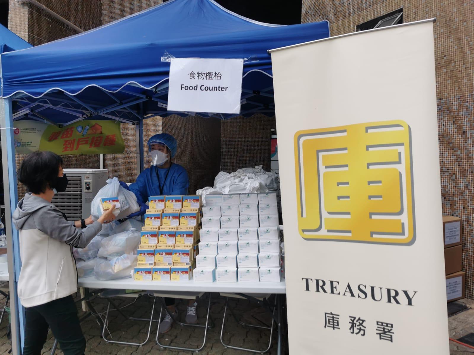 The Government yesterday (April 16) enforced "restriction-testing declaration" and compulsory testing notice in respect of the specified "restricted area" in Kwai Ming House, Kwai Hong Court, Kwai Chung. Photo shows staff members distributing food packs, rapid antigen test kits and anti-epidemic proprietary Chinese medicines donated by the Central Government to persons subject to compulsory testing in the "restricted area".