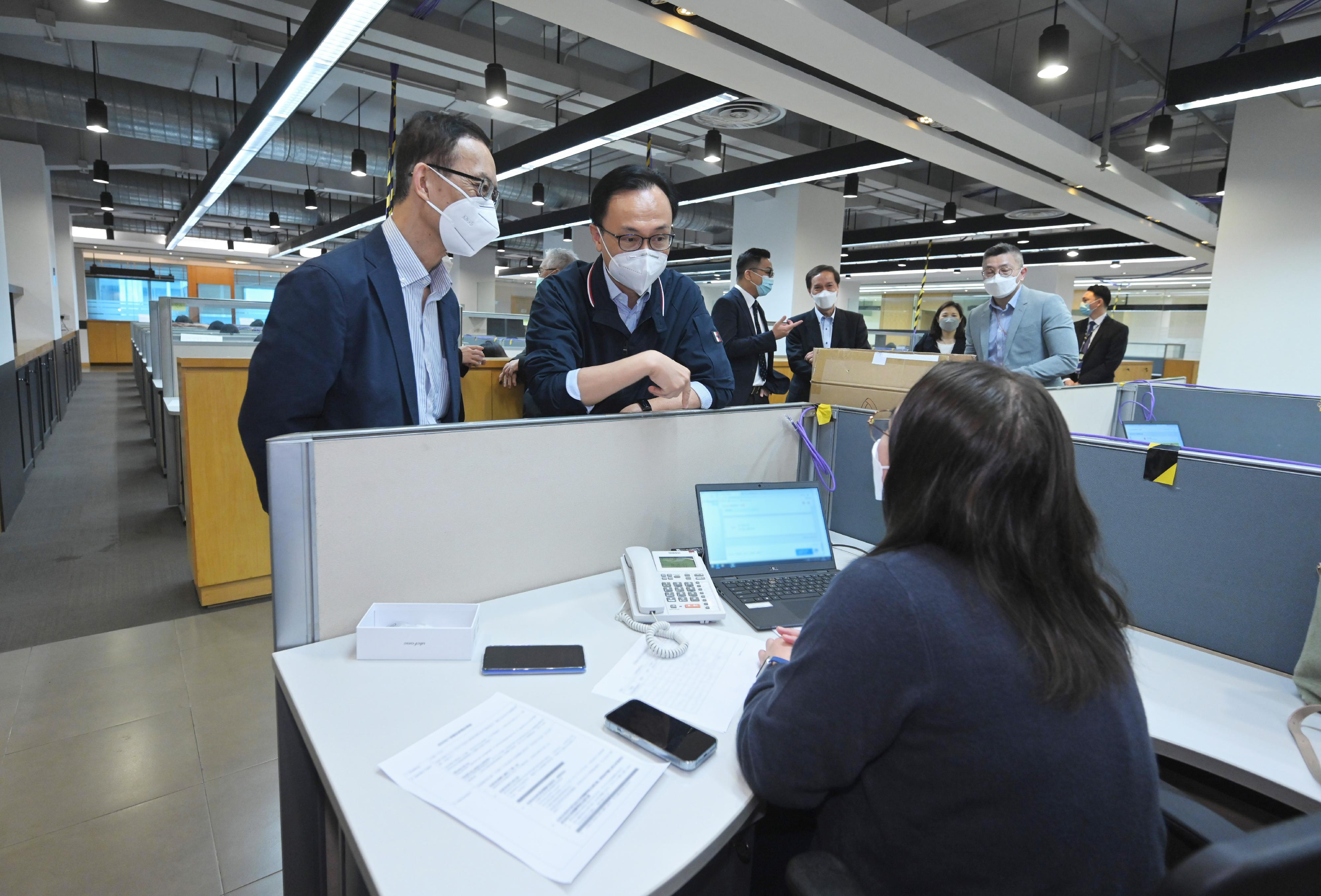 The Home Vaccination Service is open for online and phone registration starting from today (April 19). The Secretary for the Civil Service, Mr Patrick Nip, visited the call centre at the Hong Kong Spinners Industrial Building in Cheung Sha Wan to view the first-day operation of the centre. Photo shows Mr Nip (second left) talking to a student of the Caritas Institute of Higher Education who is assisting members of the public to register for the Home Vaccination Service at the call centre.
