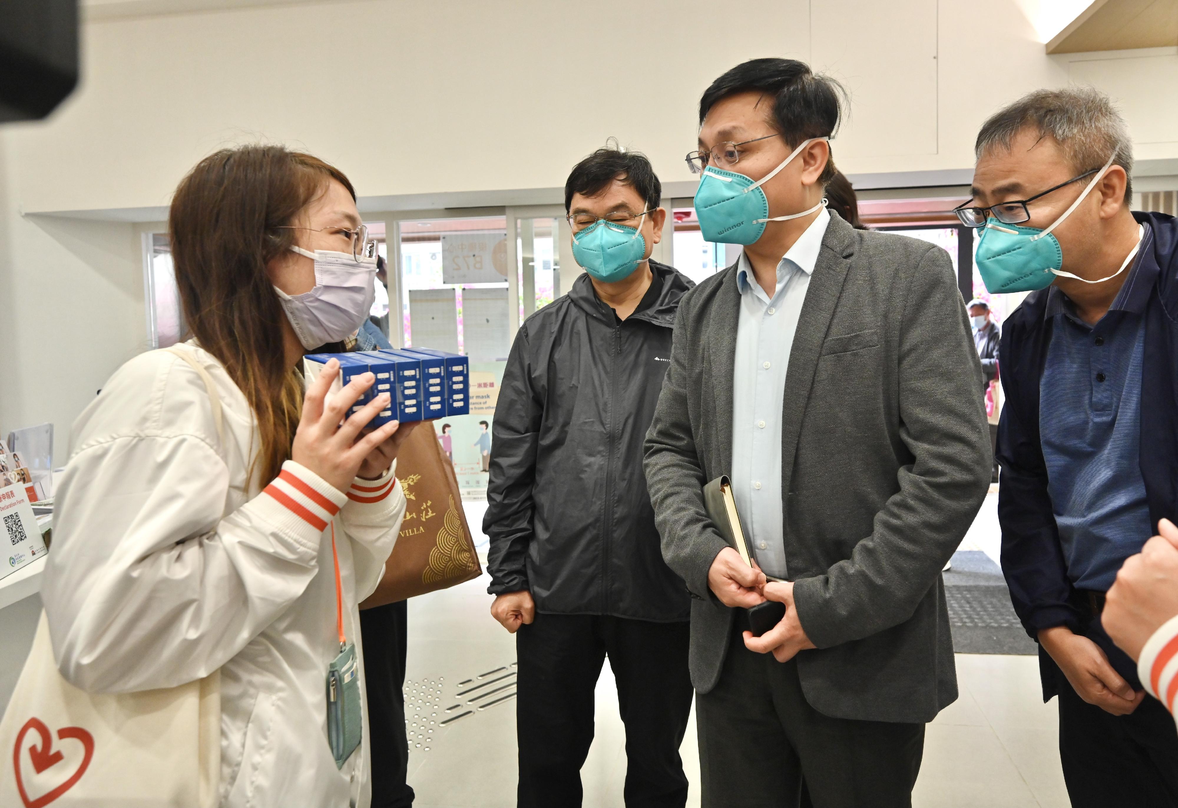 The Mainland epidemic prevention and control expert delegation deployed by the Central Authorities visited the Sham Shui Po District Health Centre (DHC) today (April 19). Photo shows a staff member of the DHC introducing the arrangement of distributing free rapid antigen test kits to the elderly, which began today to encourage elderly people to conduct frequent testing for health monitoring.
