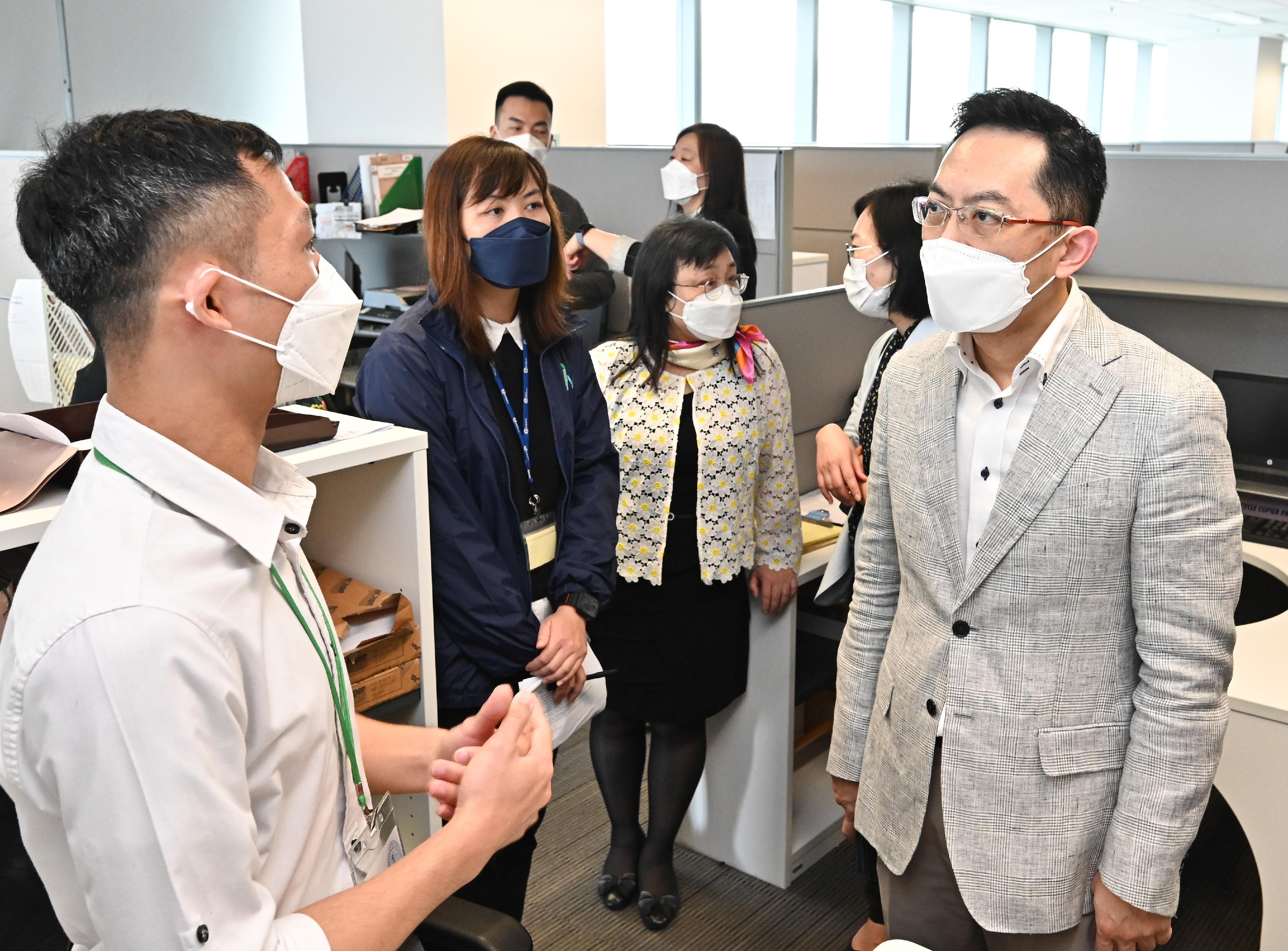 The Director of Health, Dr Ronald Lam (first right), visited the Department of Health's Emergency Hotline Centre to understand its operation. Photo shows Dr Lam being briefed by a colleague on his daily work concerning the handling of public enquiries.