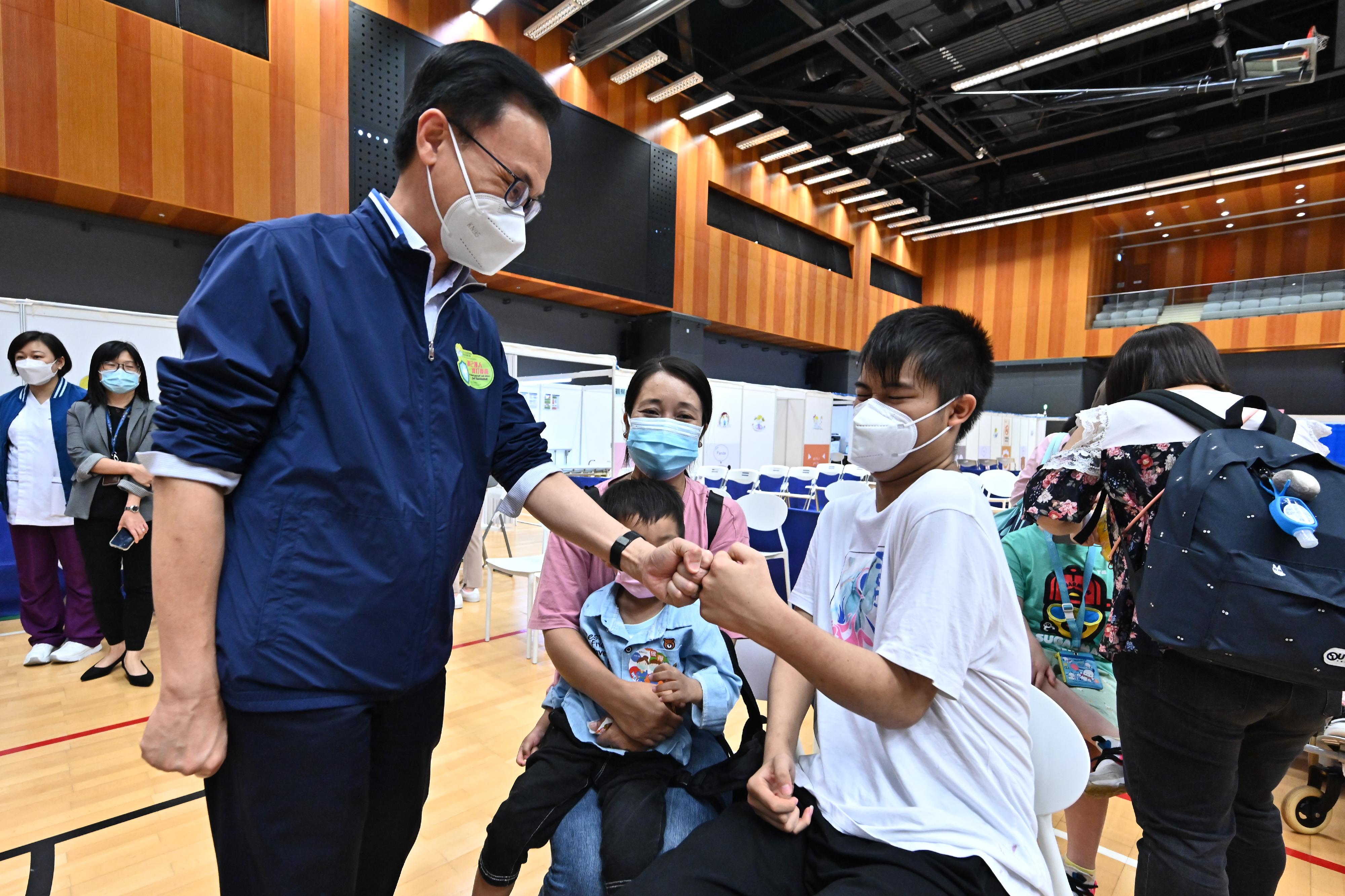 Around 300 students from 37 special schools were arranged to receive the BioNTech vaccine at the Children Community Vaccination Centres (CCVCs) at Yuen Chau Kok Sports Centre in Sha Tin and Hong Kong Children's Hospital in Kowloon Bay at special booking time slots this morning (April 27). Photo shows the Secretary for the Civil Service, Mr Patrick Nip (left), giving encouragement to a student (right) who just received his COVID-19 vaccine at the CCVC at Yuen Chau Kok Sports Centre.