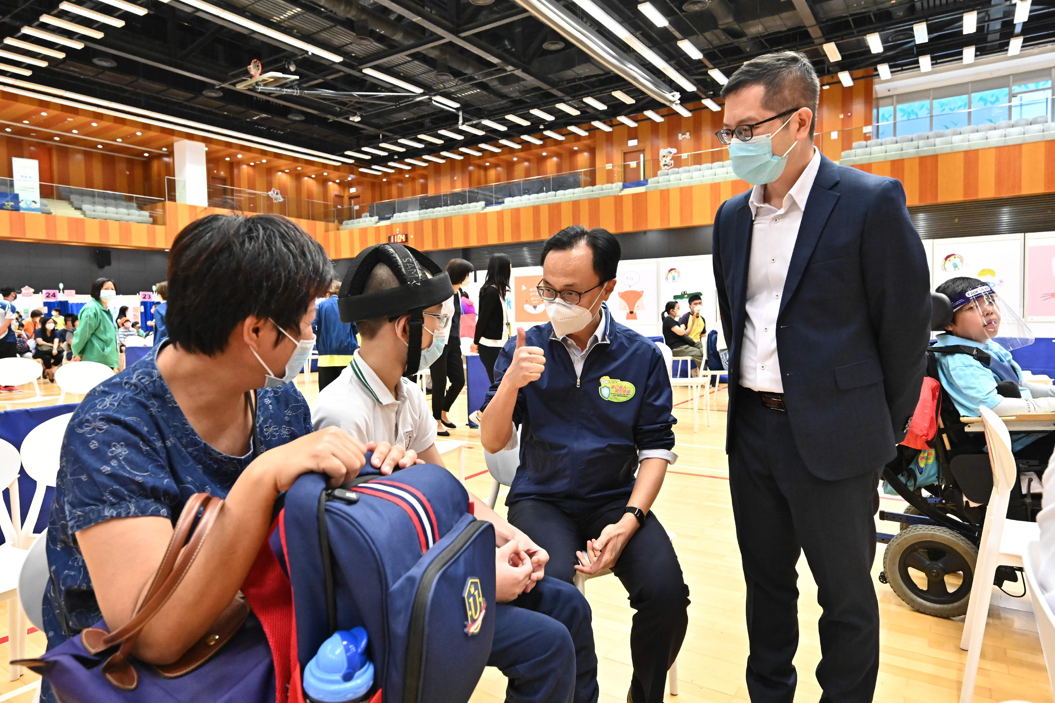 Around 300 students from 37 special schools were arranged to receive the BioNTech vaccine at the Children Community Vaccination Centres (CCVCs) at Yuen Chau Kok Sports Centre in Sha Tin and Hong Kong Children's Hospital in Kowloon Bay at special booking time slots this morning (April 27). Photo shows the Secretary for the Civil Service, Mr Patrick Nip (second right), giving encouragement to a student at the CCVC at Yuen Chau Kok Sports Centre in Sha Tin. Looking on is the Principal of the SAHK Jockey Club Elaine Field School, Mr Suen Yau-man (first right).