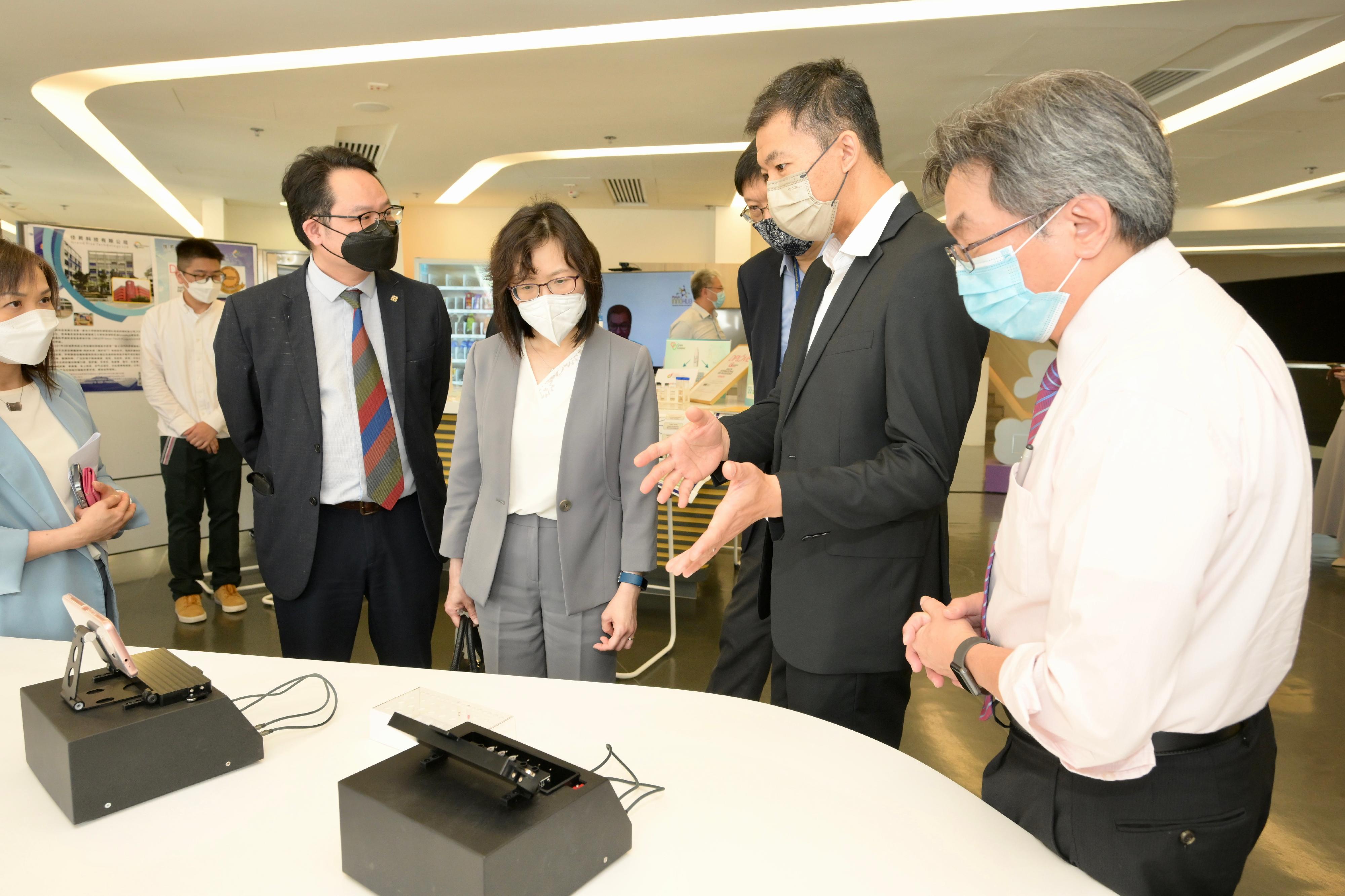 創新科技署署長潘婷婷四月二十七日到訪香港理工大學與研究團隊會面及交流。圖示潘婷婷（右三）聽取有關便攜式新冠病毒核酸檢測儀的簡介。