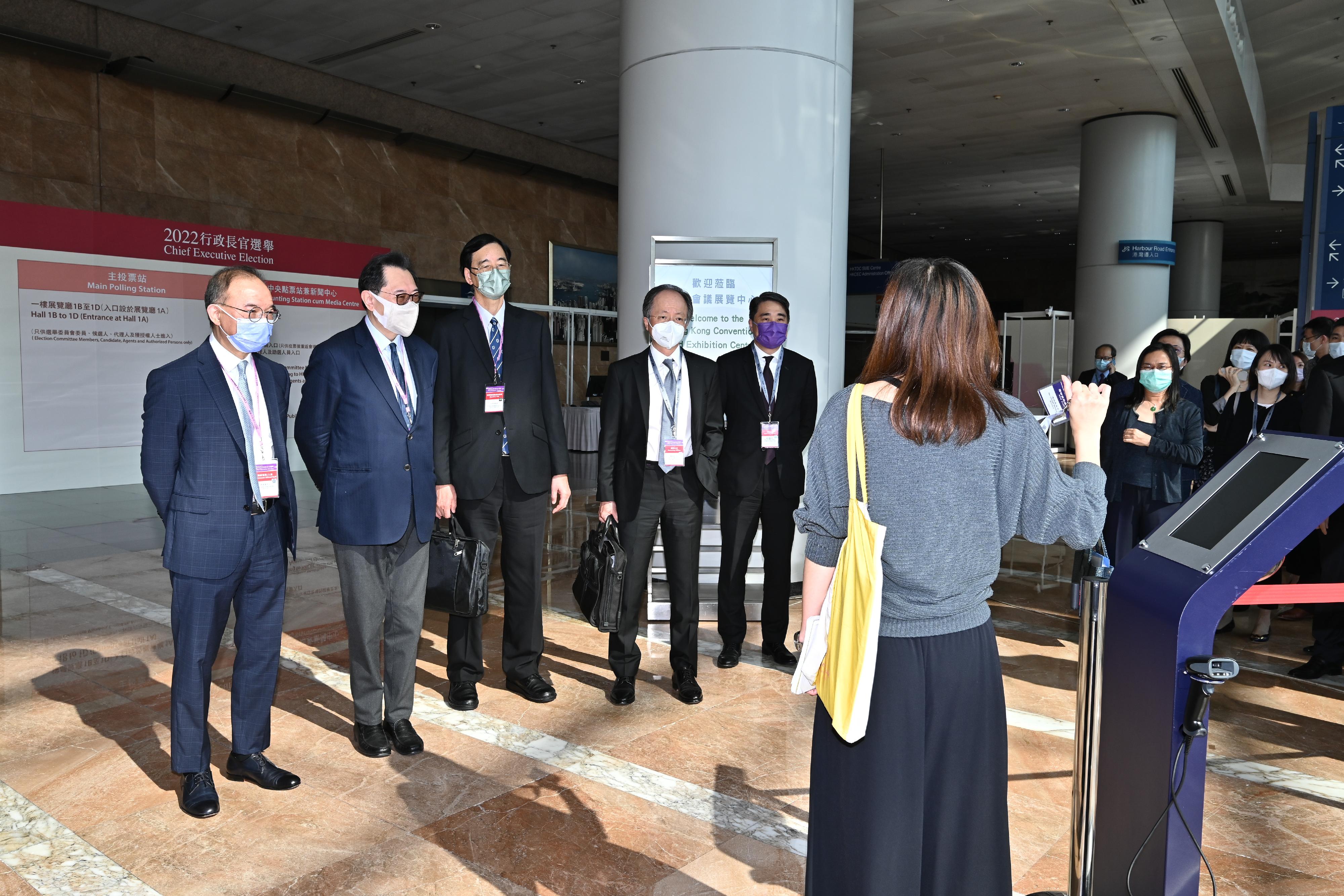 The Chairman of the Electoral Affairs Commission (EAC), Mr Justice Barnabas Fung Wah (second left), the Secretary for Constitutional and Mainland Affairs, Mr Erick Tsang Kwok-wai (first left), EAC member Professor Daniel Shek (third left), and the Returning Officer, Mr Justice Keith Yeung Kar-hung (fourth left), were briefed by staff of the Registration and Electoral Office during their visit to the main polling station and central counting station cum media centre of the 2022 Chief Executive Election at the Hong Kong Convention and Exhibition Centre in Wan Chai today (May 4).
