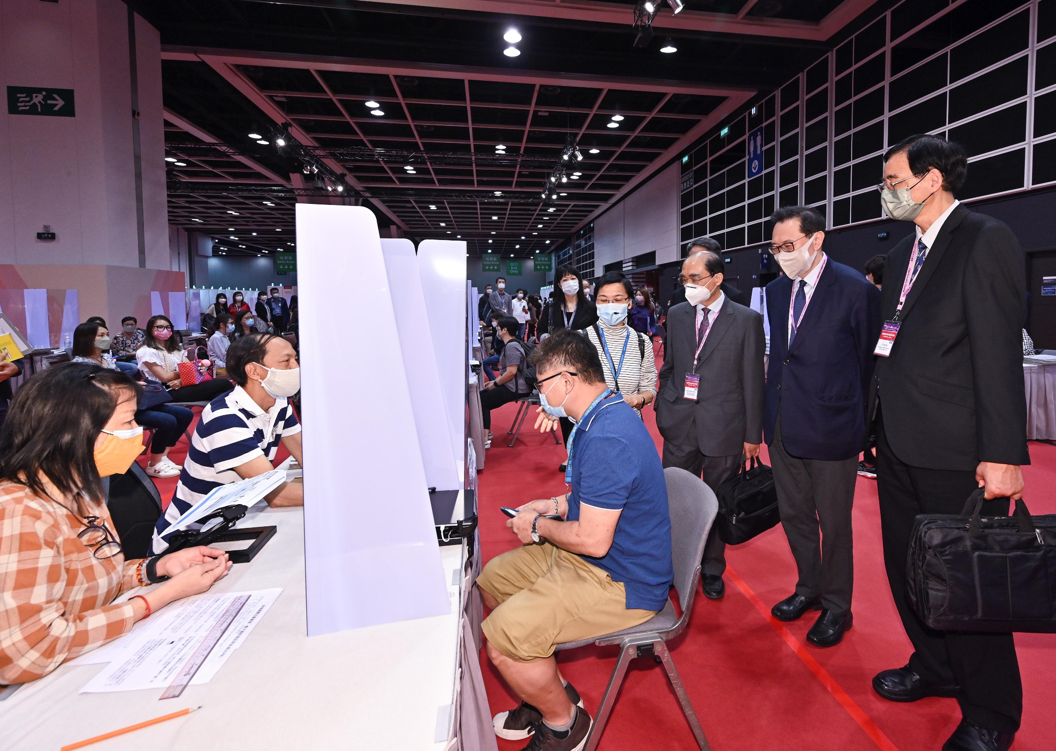The Chairman of the Electoral Affairs Commission (EAC), Mr Justice Barnabas Fung Wah (second right), EAC members Mr Arthur Luk, SC (third right), and Professor Daniel Shek (first right), today (May 4) visited the main polling station of the 2022 Chief Executive Election at the Hong Kong Convention and Exhibition Centre in Wan Chai and inspected the training with practical sessions and simulated activities for staff. Photo shows polling staff in a simulation of issuing a ballot paper at an issuing desk.