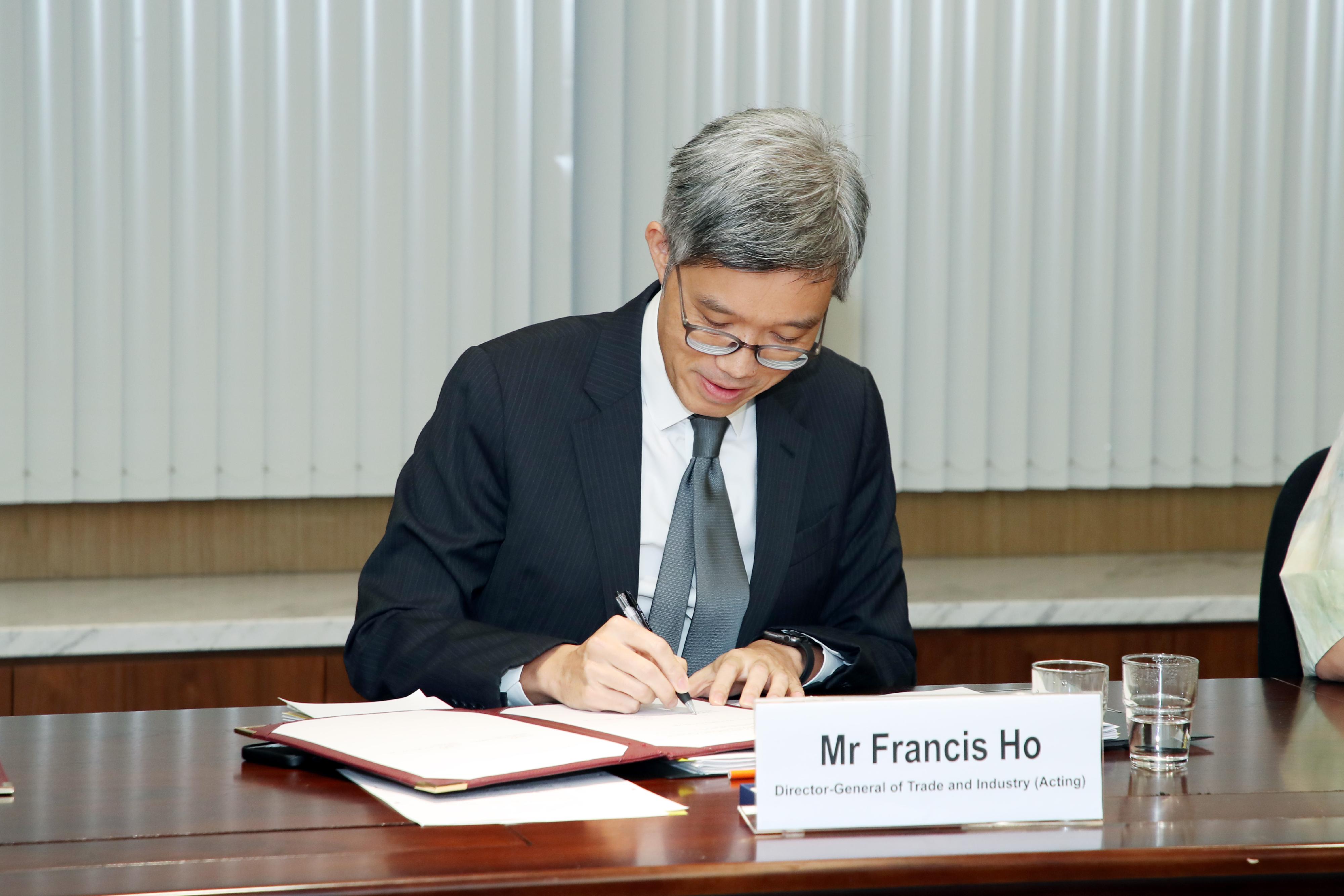 香港和新西蘭在今日（五月五日）舉行的《緊密經貿合作協定》下的聯合委員會視像會議上簽訂三份實施安排，就原產地規則、衞生與植物衞生措施和政府採購方面，促進現行的合作和溝通。圖示署理工業貿易署署長何兆康簽署實施安排。