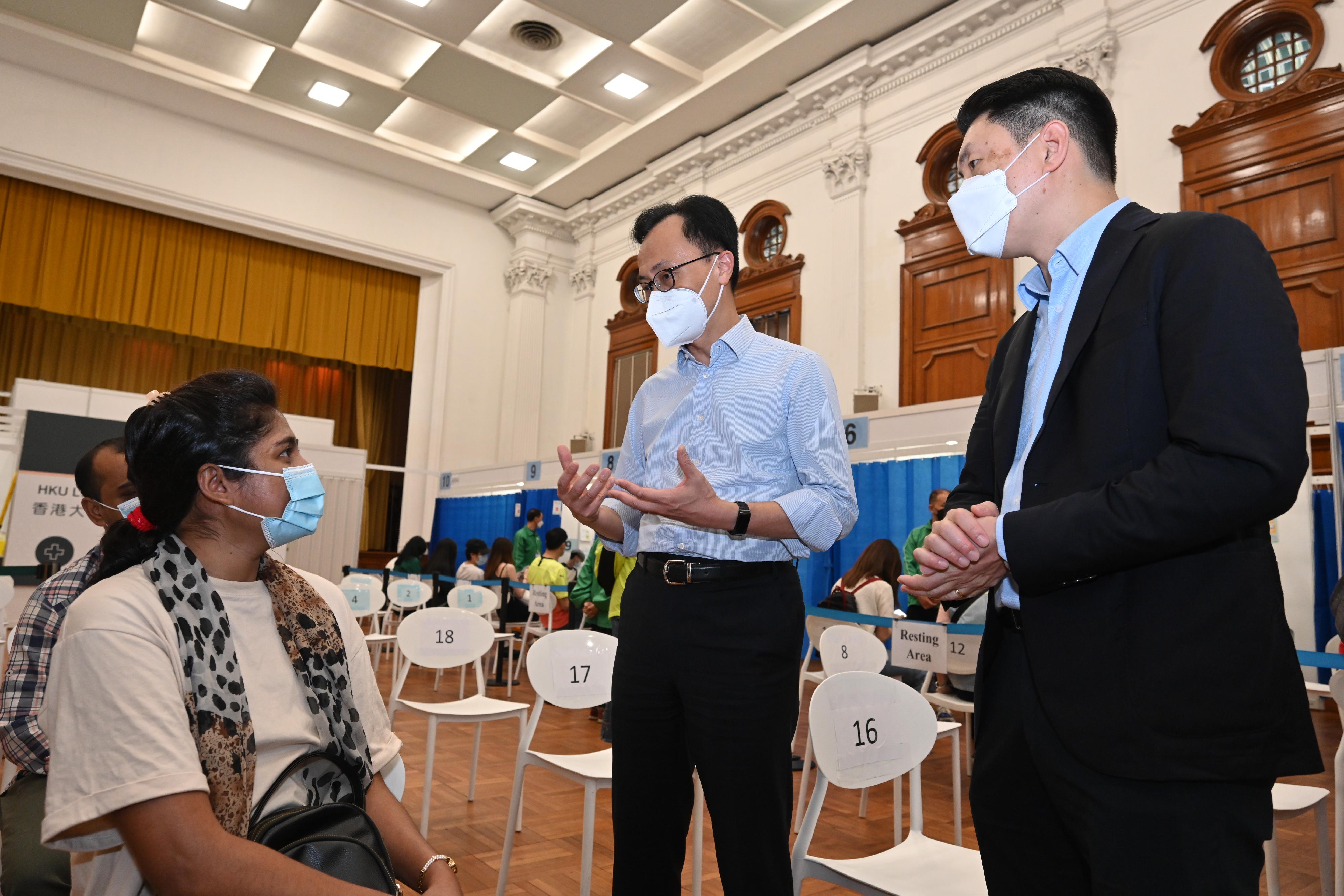 The Secretary for the Civil Service, Mr Patrick Nip, today (May 13) visited the Community Vaccination Centre (CVC) at Loke Yew Hall of the University of Hong Kong (HKU) to inspect its operation and express gratitude to the medical team and administrative support staff. Photo shows Mr Nip (centre) chatting with a member of the public who had just received COVID-19 vaccination. Looking on is the Doctor-in-charge of the CVC at Loke Yew Hall of HKU, Professor Ivan Hung (right).