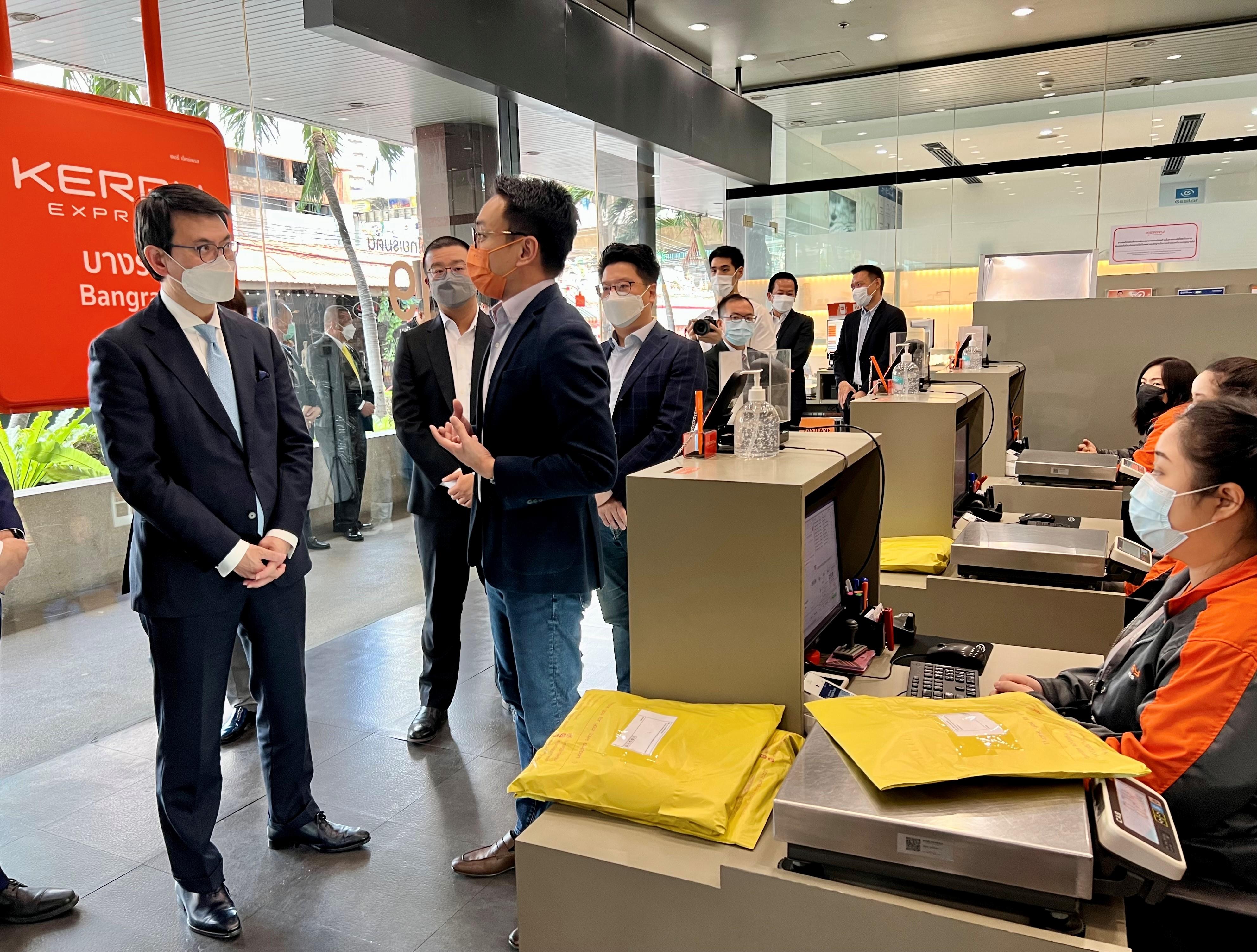 The Secretary for Commerce and Economic Development, Mr Edward Yau, met with the Thai business sector in Bangkok, Thailand, today (May 19). He also visited a Hong Kong-founded logistics company to learn about the development of local enterprises. Photo shows Mr Yau (left) being briefed by a representative of the logistics company.