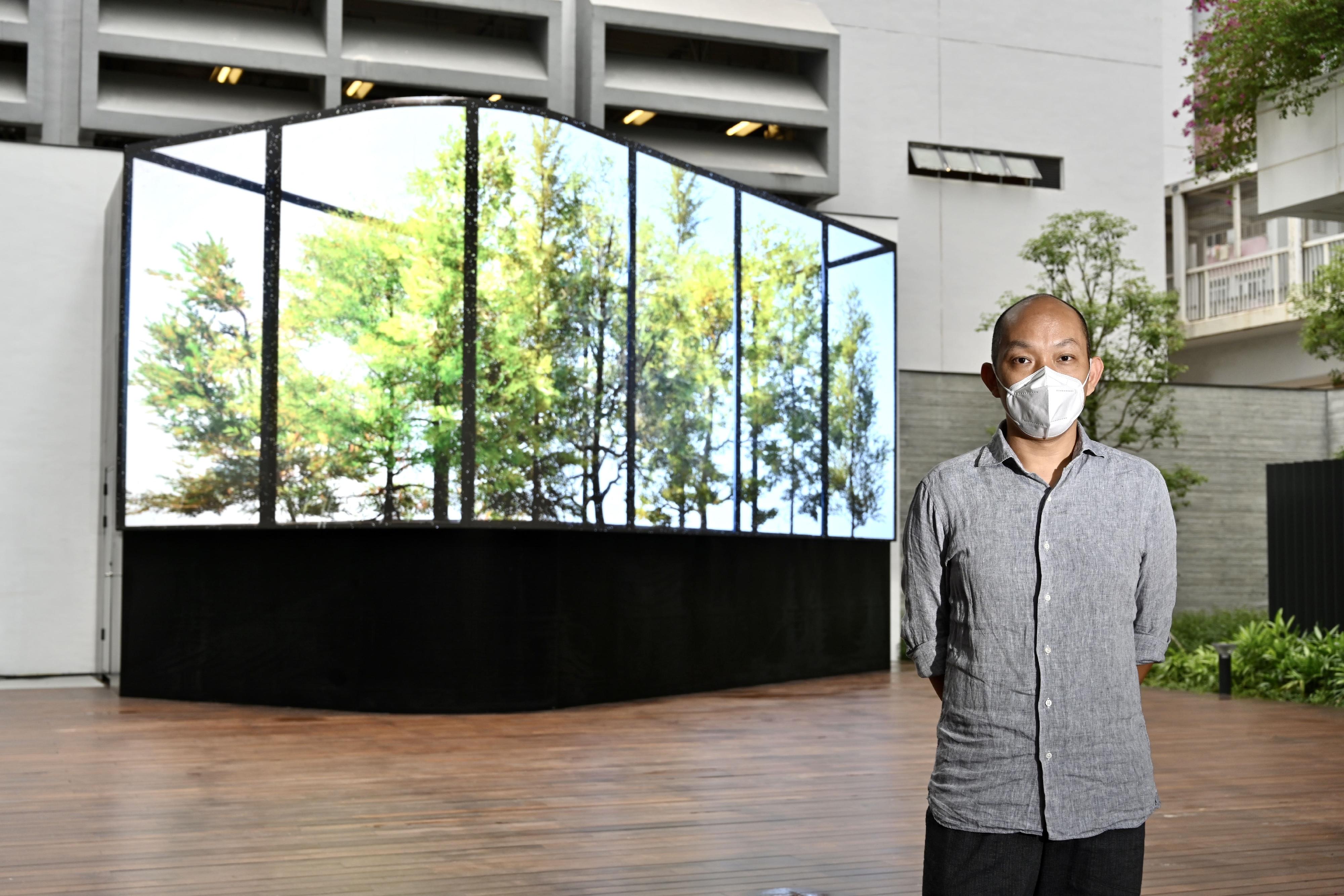 The new extension of the Oil Street Art Space is open to the public tomorrow (May 24). Photo shows Ng Tsz-kwan, the guest curator and artist of the "Digital Muse" exhibition, and the digital art work "Nearly Real-time Digital Greenhouse" created by him. 