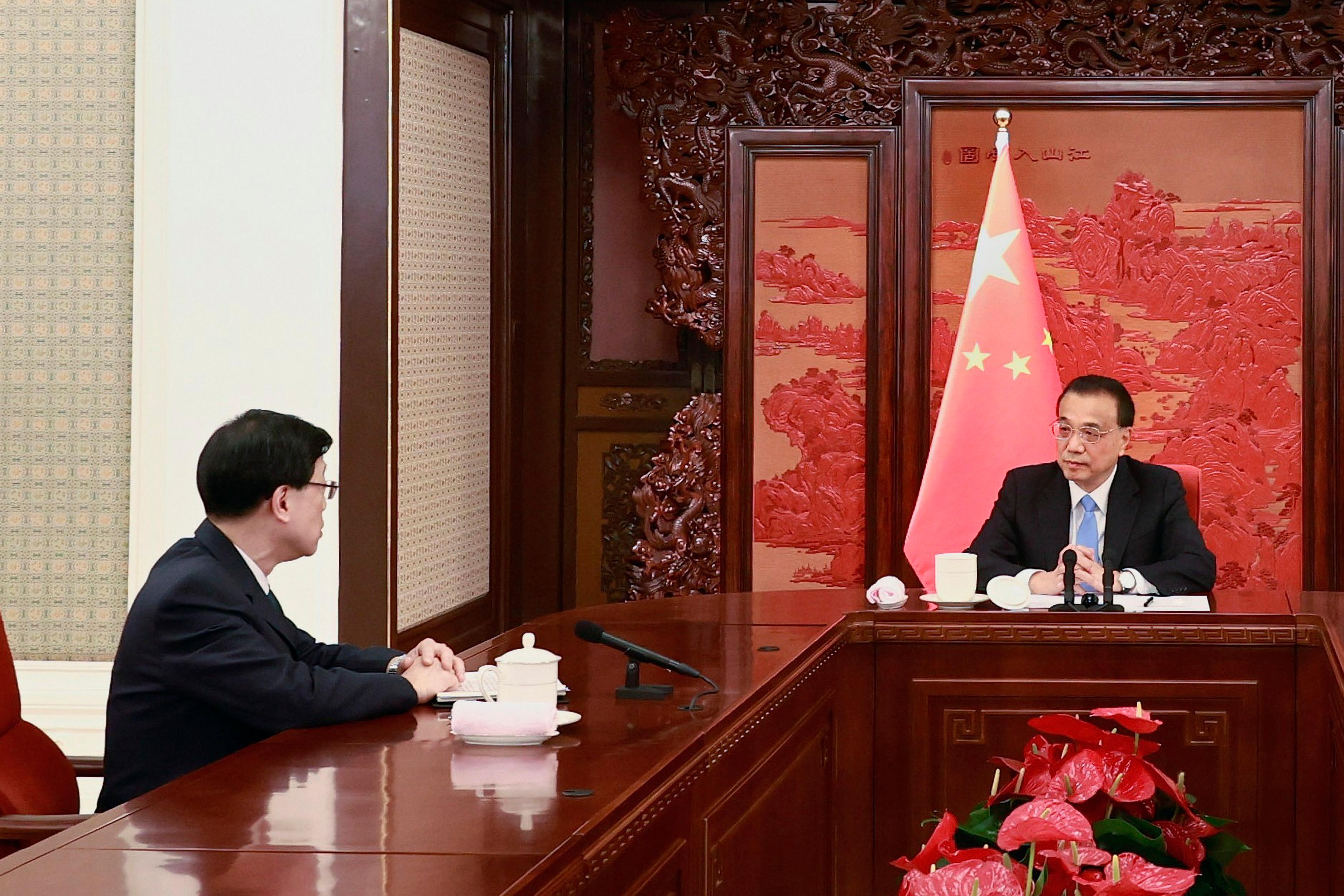 The Chief Executive-elect, Mr John Lee (left), receives from Premier Li Keqiang (right) the instrument of appointment as the sixth-term Chief Executive of the Hong Kong Special Administrative Region of the People's Republic of China in Beijing today (May 30).