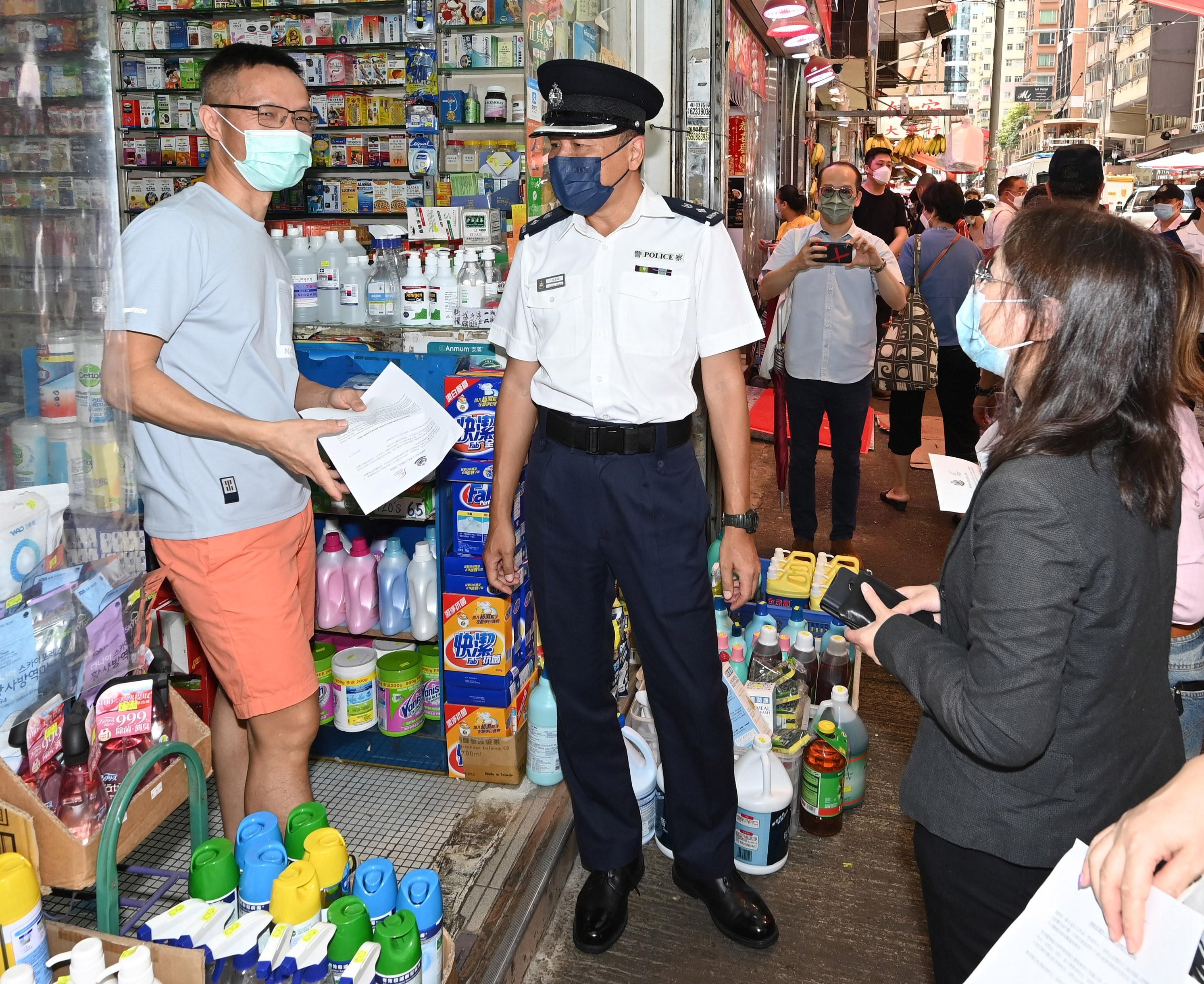 Deputy Director of Food and Environmental Hygiene Miss Diane Wong (right), and the Deputy District Commander (Eastern) of the Hong Kong Police Force, Mr Louis Chan (centre), distributed notices at Eastern District today (May 30) to shop operators, reminding them and other stakeholders not to extend business areas illegally by placing goods or articles in public places or on carriageways and causing obstruction to pedestrian and vehicular flow.