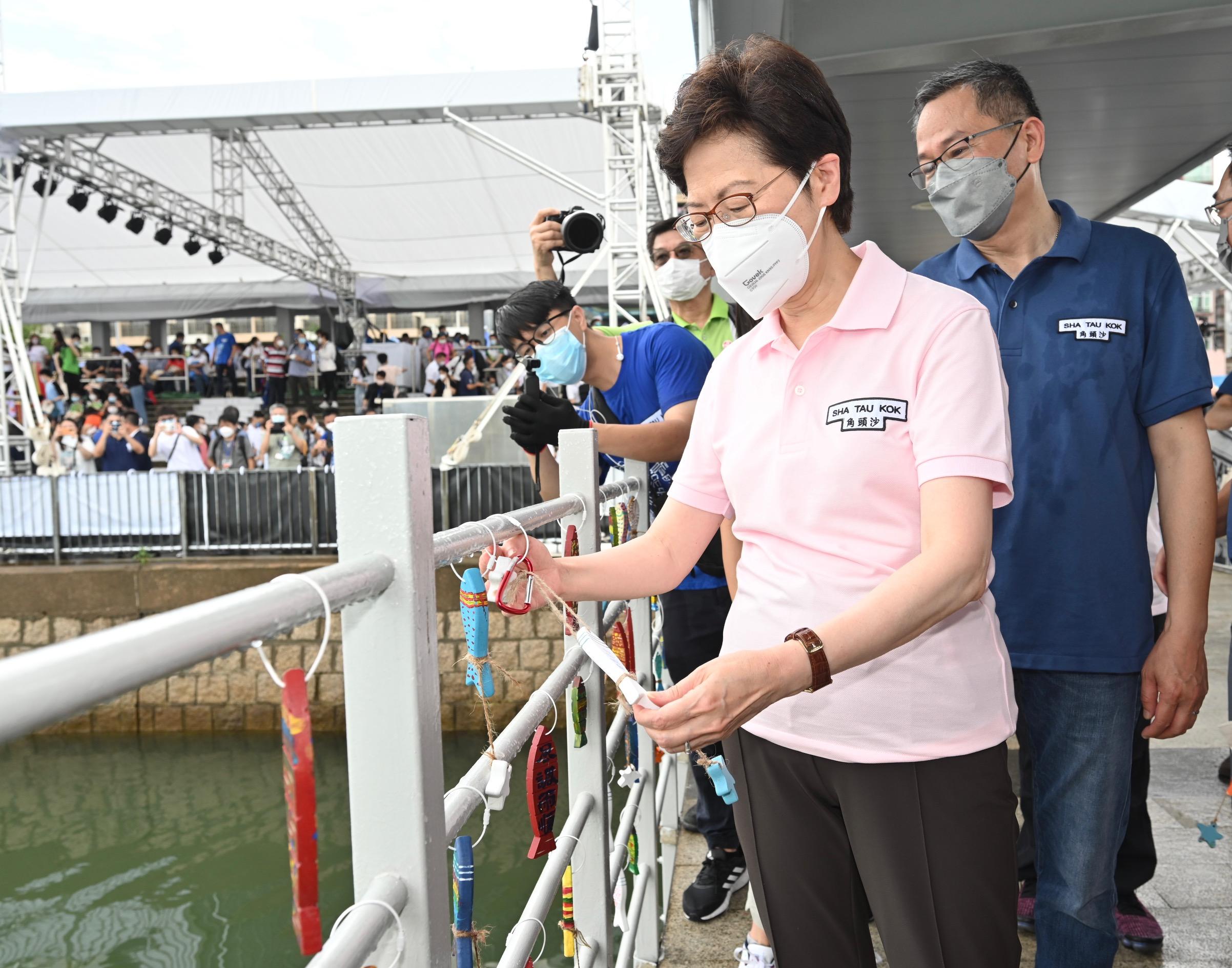 The Chief Executive, Mrs Carrie Lam, attended the opening ceremony of Sha Tau Kok Pier today (June 3). Photo shows Mrs Lam (first left) hanging a wooden fish-shape ornament designed with the concept of "Sha Tau Kok Fish Lantern Dance" on the pier railing. 