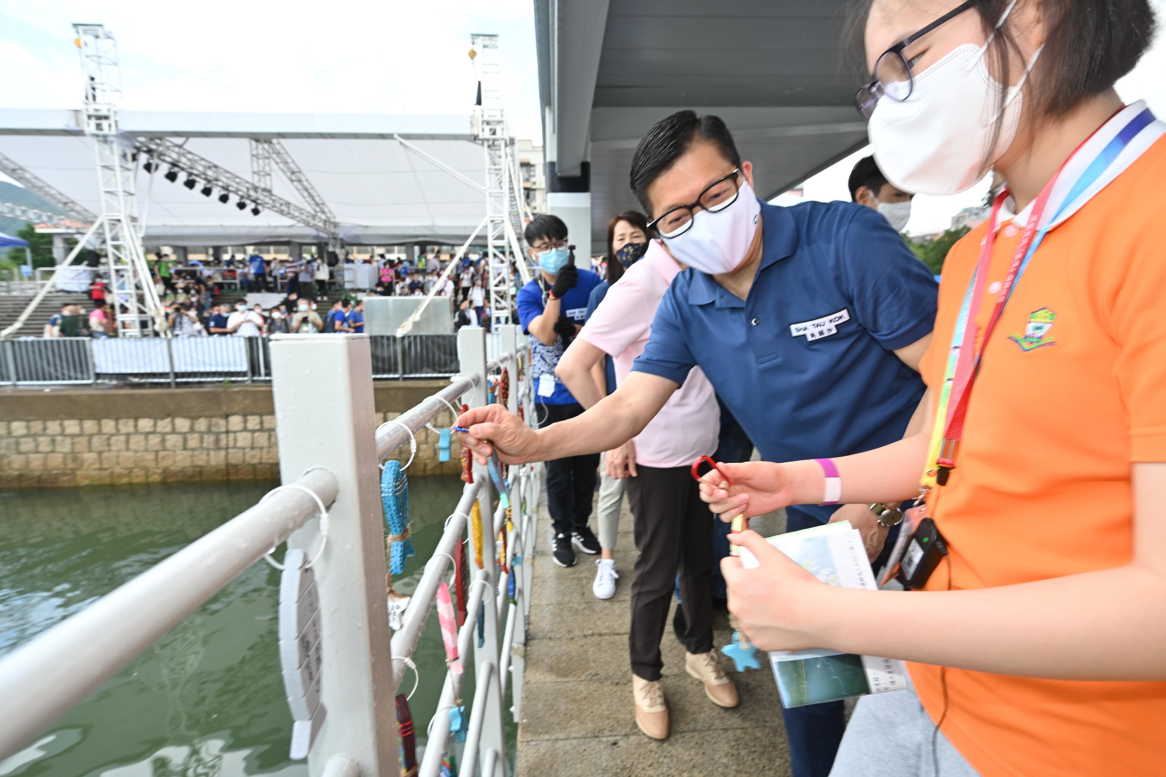 The Chief Executive, Mrs Carrie Lam, officiated at the opening ceremony of Sha Tau Kok Pier today (June 3). Photo shows the Secretary for Security, Mr Tang Ping-keung (second right), hanging a wooden fish-shape ornament designed with the concept of “Sha Tau Kok Fish Lantern Dance” on the pier railing.