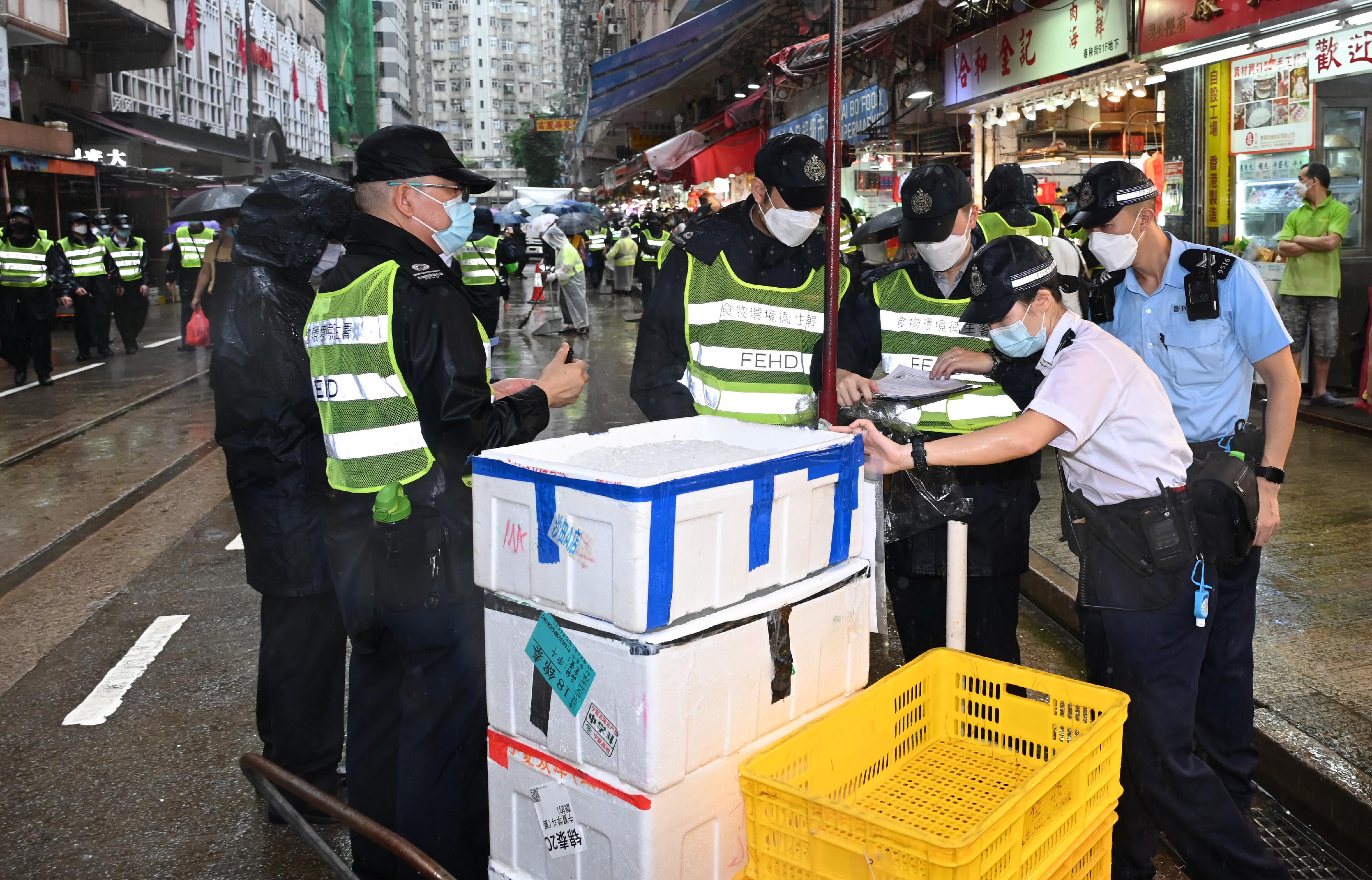 To tackle the illegal shop extension and obstruction problems, the Food and Environmental Hygiene Department (FEHD) and the Police formally launched the second phase of the trial scheme since June 7 (Tuesday) in Sham Shui Po, Yuen Long and Eastern Districts, to conduct joint operations with new enforcement strategy. Photo shows the joint operation of the FEHD and the Police in the Eastern District.