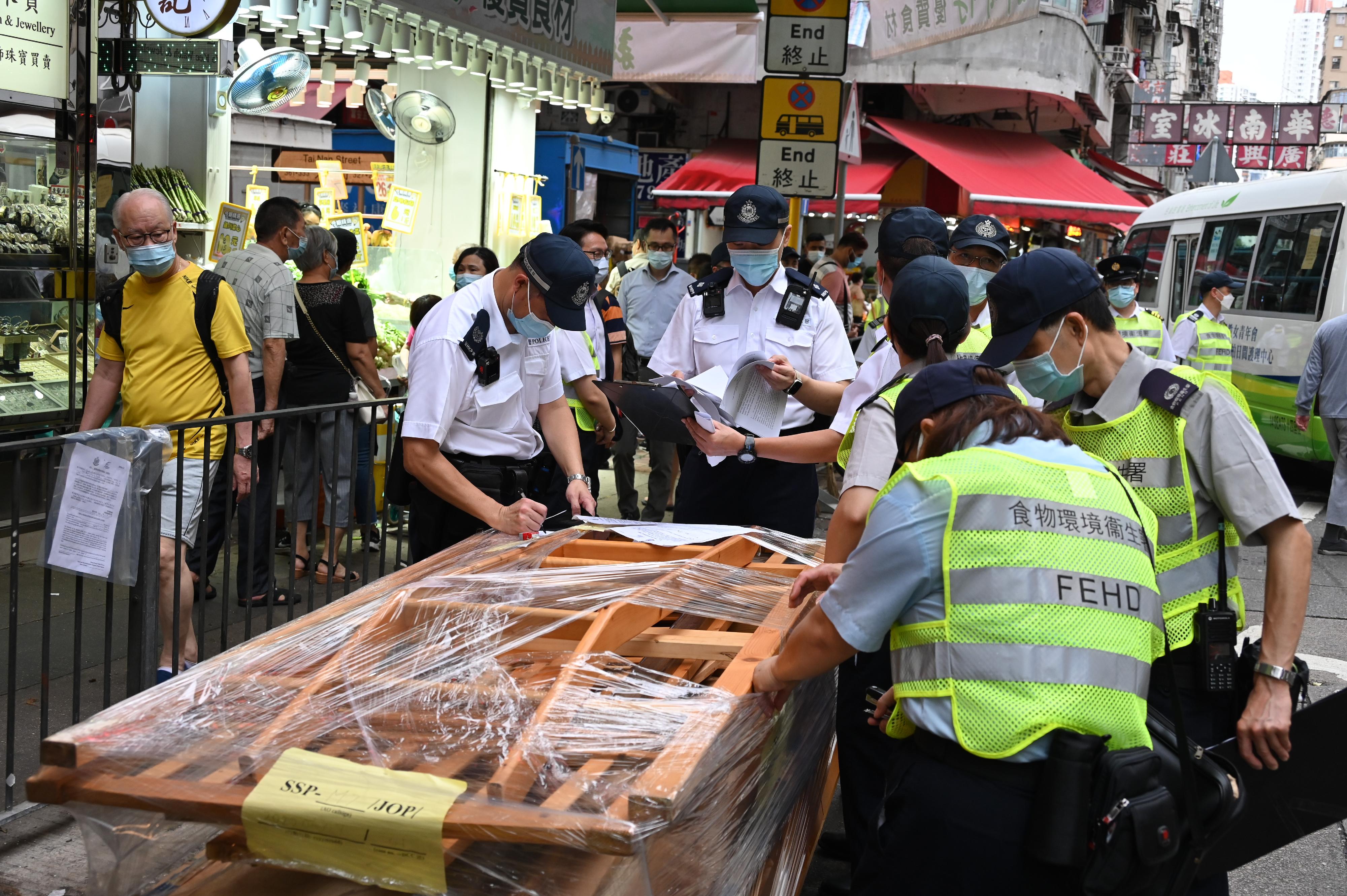 To tackle the illegal shop extension and obstruction problems, the Food and Environmental Hygiene Department (FEHD) and the Police formally launched the second phase of the trial scheme since June 7 (Tuesday) in Sham Shui Po, Yuen Long and Eastern Districts, to conduct joint operations with new enforcement strategy. Photo shows the joint operation of the FEHD and the Police in Sham Shui Po.