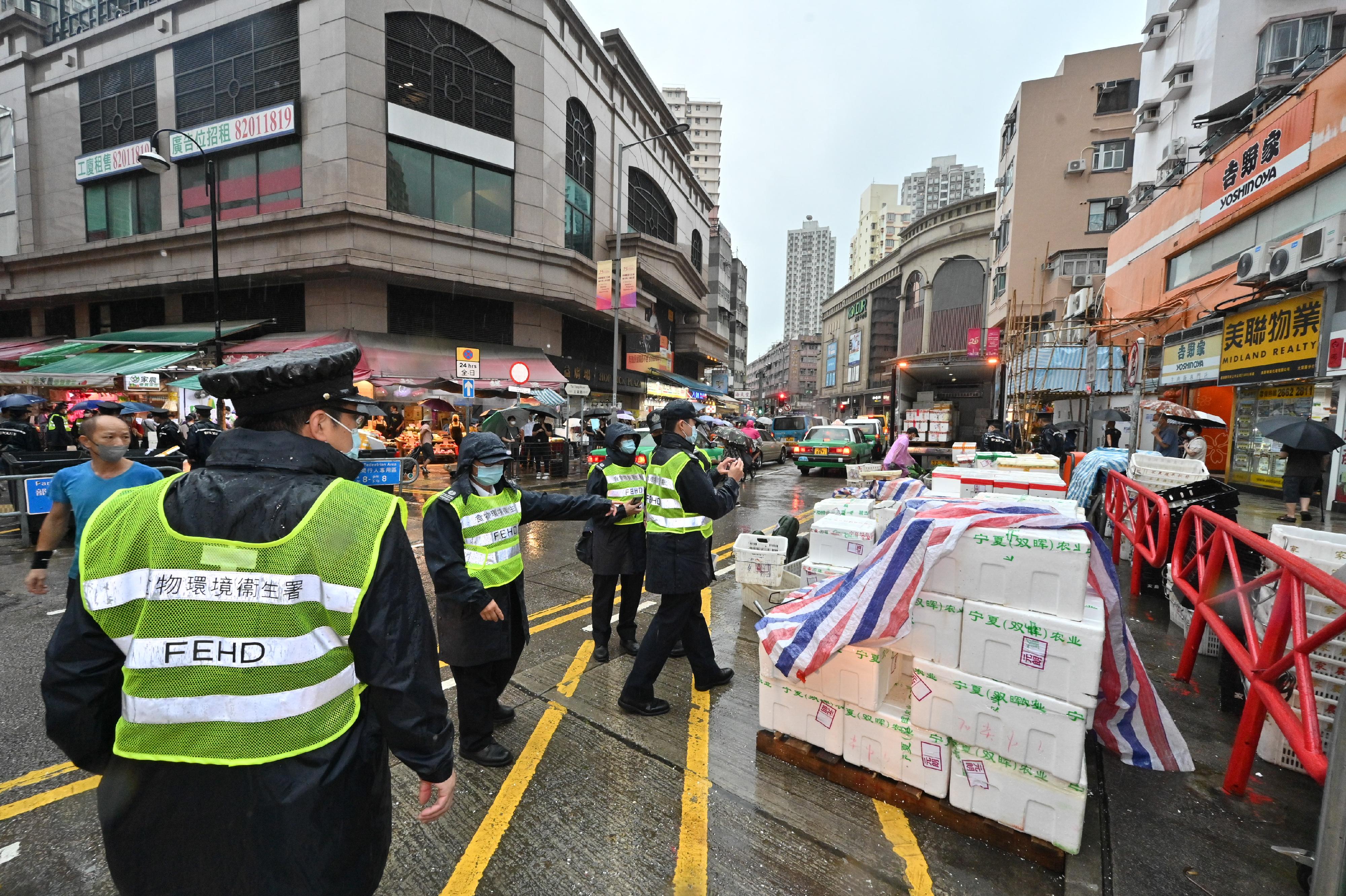 To tackle the illegal shop extension and obstruction problems, the Food and Environmental Hygiene Department (FEHD) and the Police formally launched the second phase of the trial scheme since June 7 (Tuesday) in Sham Shui Po, Yuen Long and Eastern Districts, to conduct joint operations with new enforcement strategy. Photo shows the joint operation of the FEHD and the Police in Yuen Long.