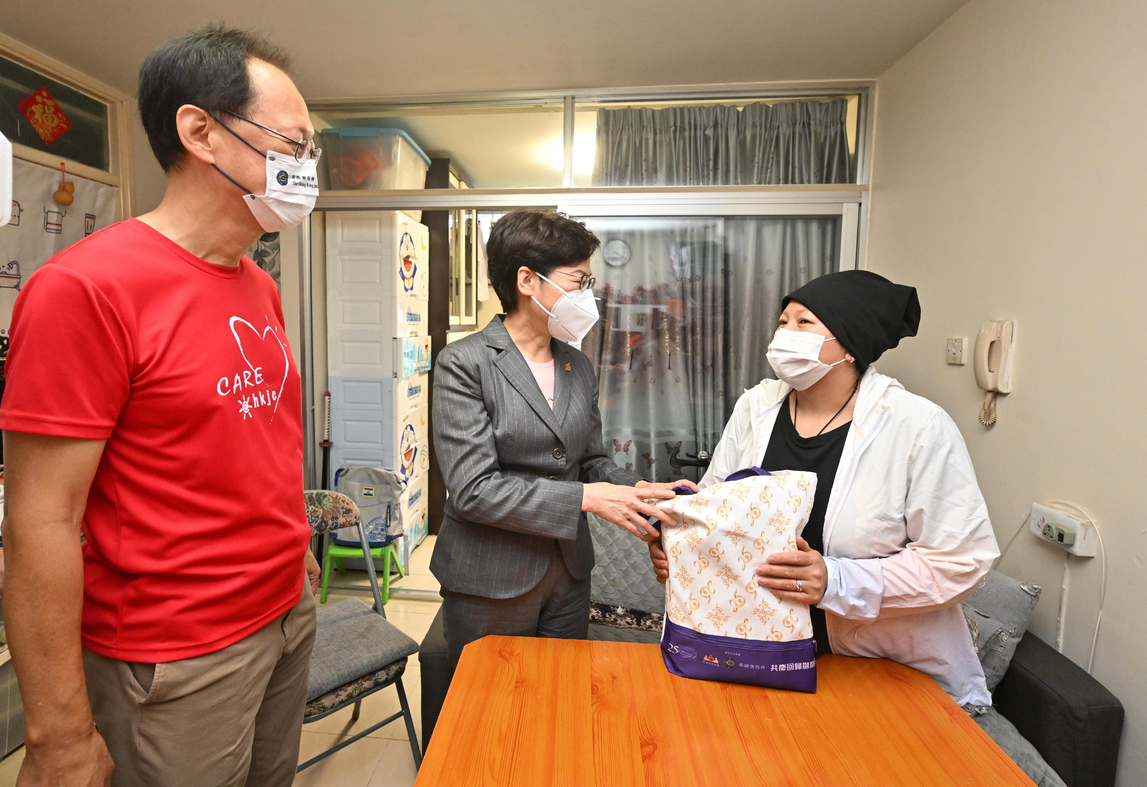 The Chief Executive, Mrs Carrie Lam, visited Upper Wong Tai Sin Estate today (June 11). Photo shows Mrs Lam (centre) accompanied by the Chairman of the Hong Kong Jockey Club, Mr Philip Chen (left), visiting a resident to learn about her needs and daily life and gave a gift pack to her.