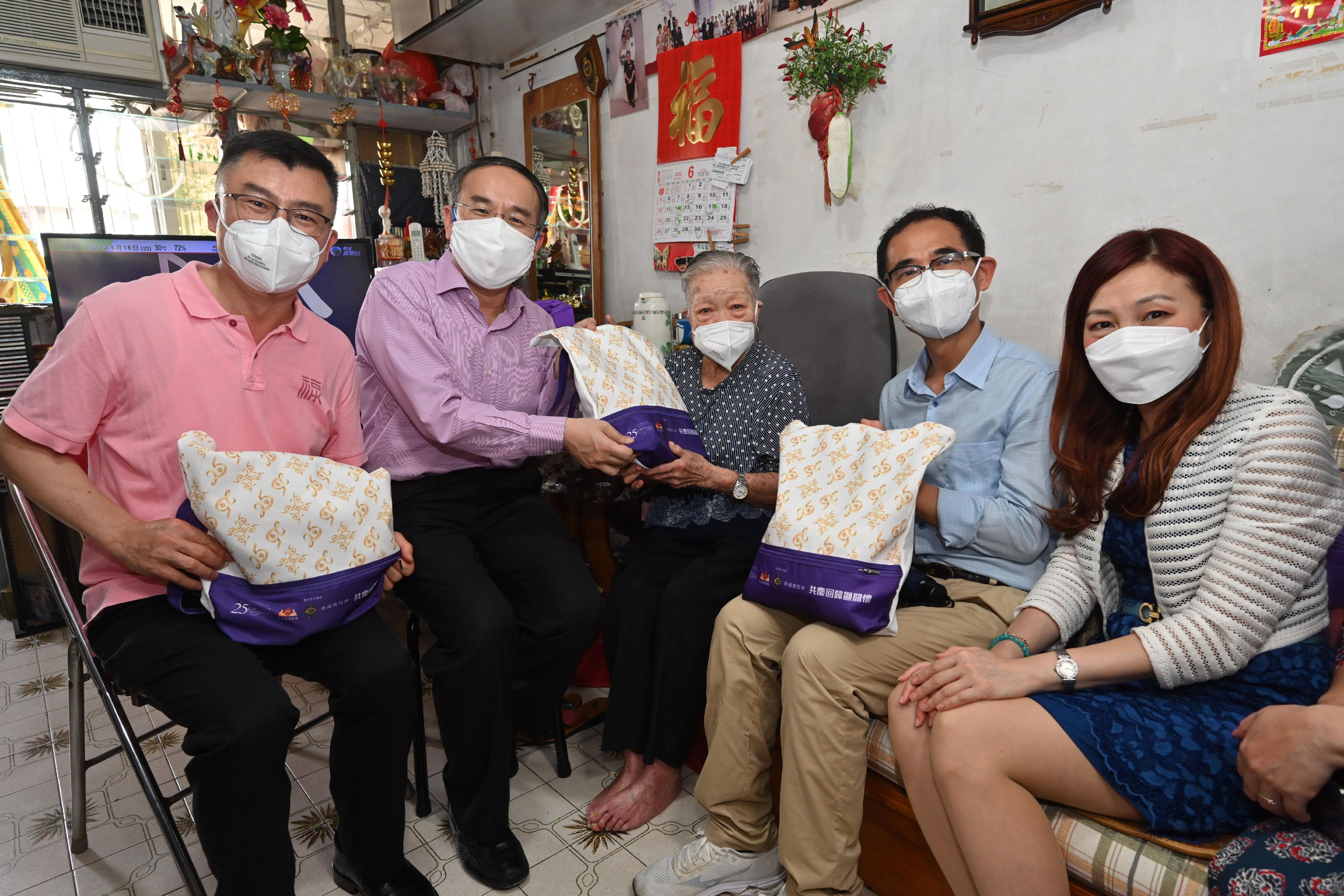 The Secretary for Financial Services and the Treasury, Mr Christopher Hui, today (June 16) visited Sha Tin District to distribute gift packs in celebration of the 25th anniversary of the establishment of the Hong Kong Special Administrative Region. Photo shows Mr Hui (second left) presenting a gift pack to an elderly person living alone in Sha Kok Estate. Looking on is the District Officer (Sha Tin), Miss Carol Or (right).