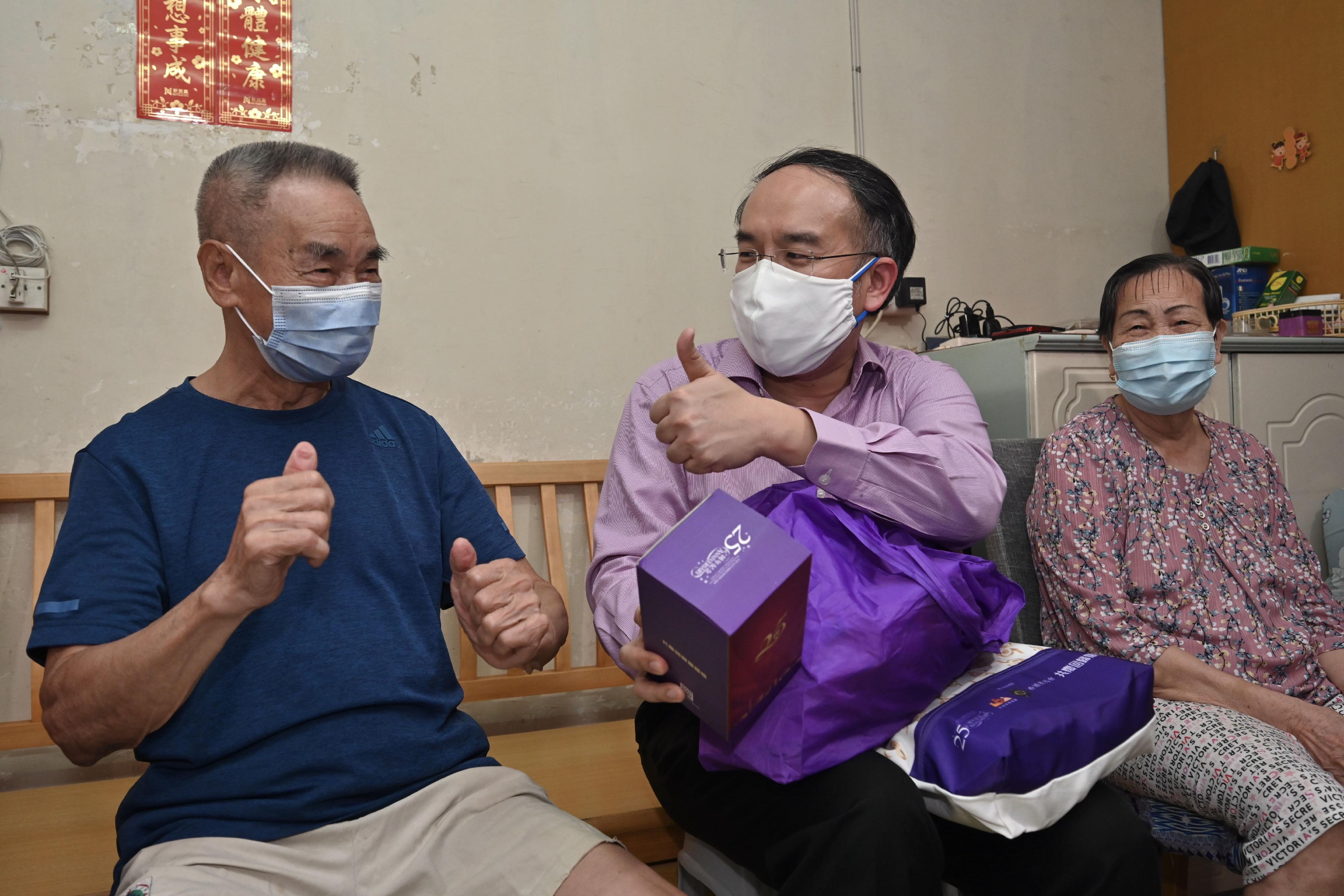 The Secretary for Financial Services and the Treasury, Mr Christopher Hui, today (June 16) visited Sha Tin District to distribute gift packs in celebration of the 25th anniversary of the establishment of the Hong Kong Special Administrative Region. Photo shows Mr Hui (centre) visiting an elderly doubleton household in Sha Kok Estate.











