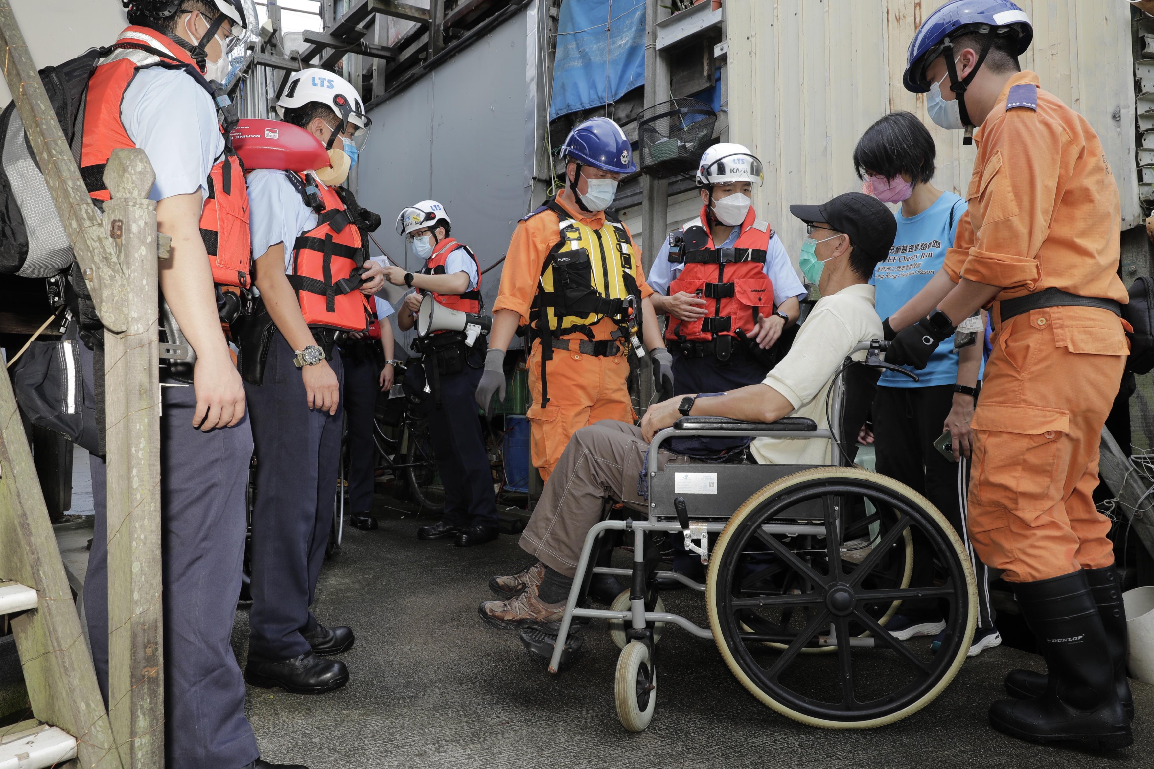 離島民政事務處今日（六月十六日）在大澳舉行跨部門水浸模擬救援及疏散演練。圖示居民模擬被困及致電求助後，警務處和民眾安全服務隊派員拯救。
