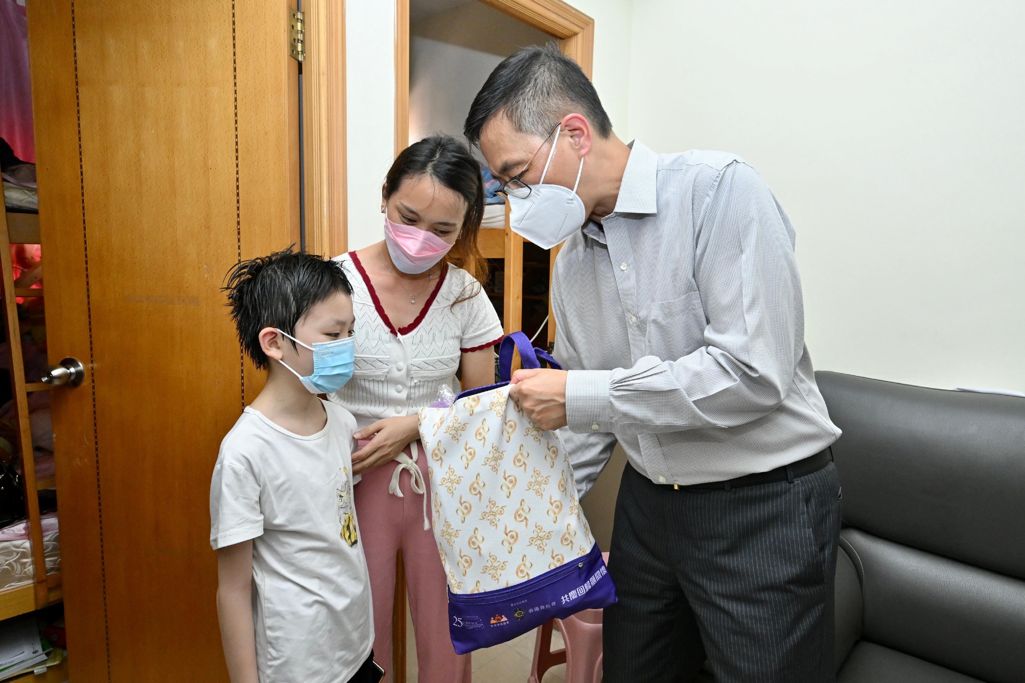The Secretary for Education, Mr Kevin Yeung, paid home visits in Kowloon City District today (June 17) as part of the Celebrations for All project to celebrate the 25th anniversary of the establishment of the Hong Kong Special Administrative Region with local residents. Photo shows Mr Yeung (right) introducing a gift pack to a grass-roots family.