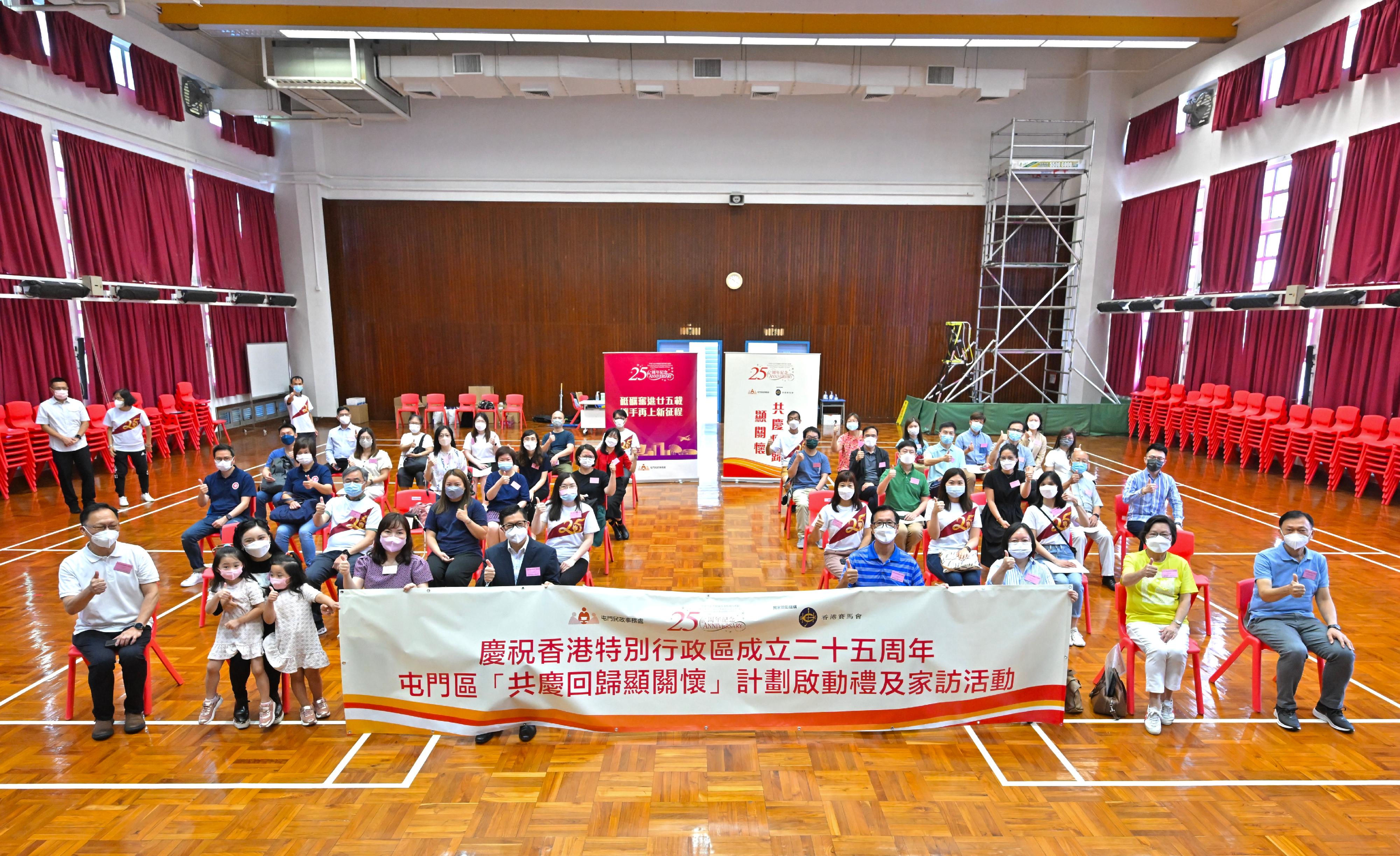 The Secretary for Security, Mr Tang Ping-keung, today (June 19) paid home visits under the Celebrations for All project in Tuen Mun District to show his care and concern for the grass-roots families, and distributed gift packs in celebration of the 25th anniversary of the establishment of the Hong Kong Special Administrative Region. Photo shows Mr Tang (front row, fifth right) posing for a photo with various non-governmental organisations and local organisations in the district before the home visits.