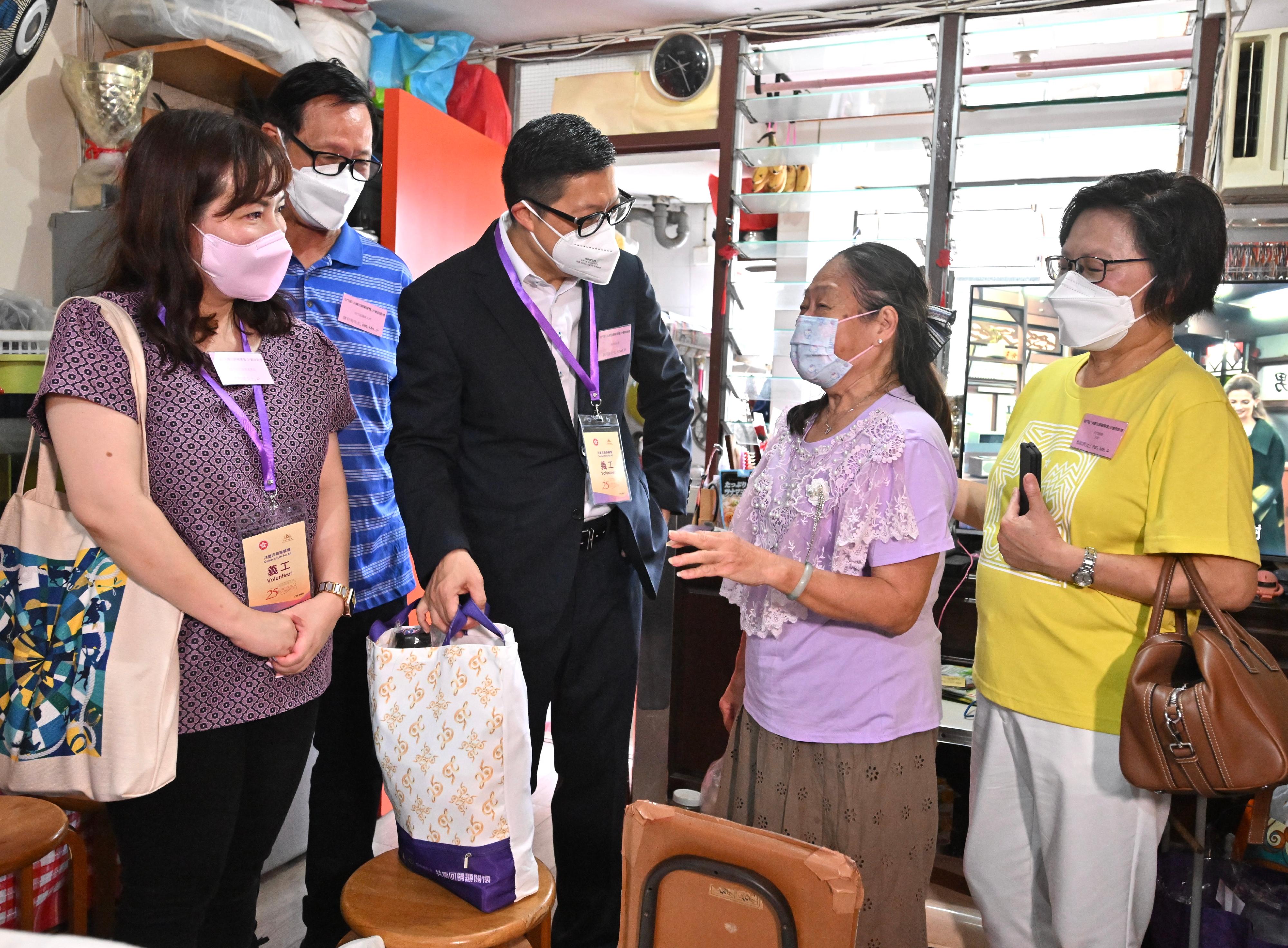 The Secretary for Security, Mr Tang Ping-keung, today (June 19) paid home visits under the Celebrations for All project in Tuen Mun District to show his care and concern for the grass-roots families, and distributed gift packs in celebration of the 25th anniversary of the establishment of the Hong Kong Special Administrative Region (HKSAR). Photo shows Mr Tang (centre) visiting an elderly household in Tai Hing Estate and sending them gift packs to convey blessings to the family on behalf of the HKSAR Government.
