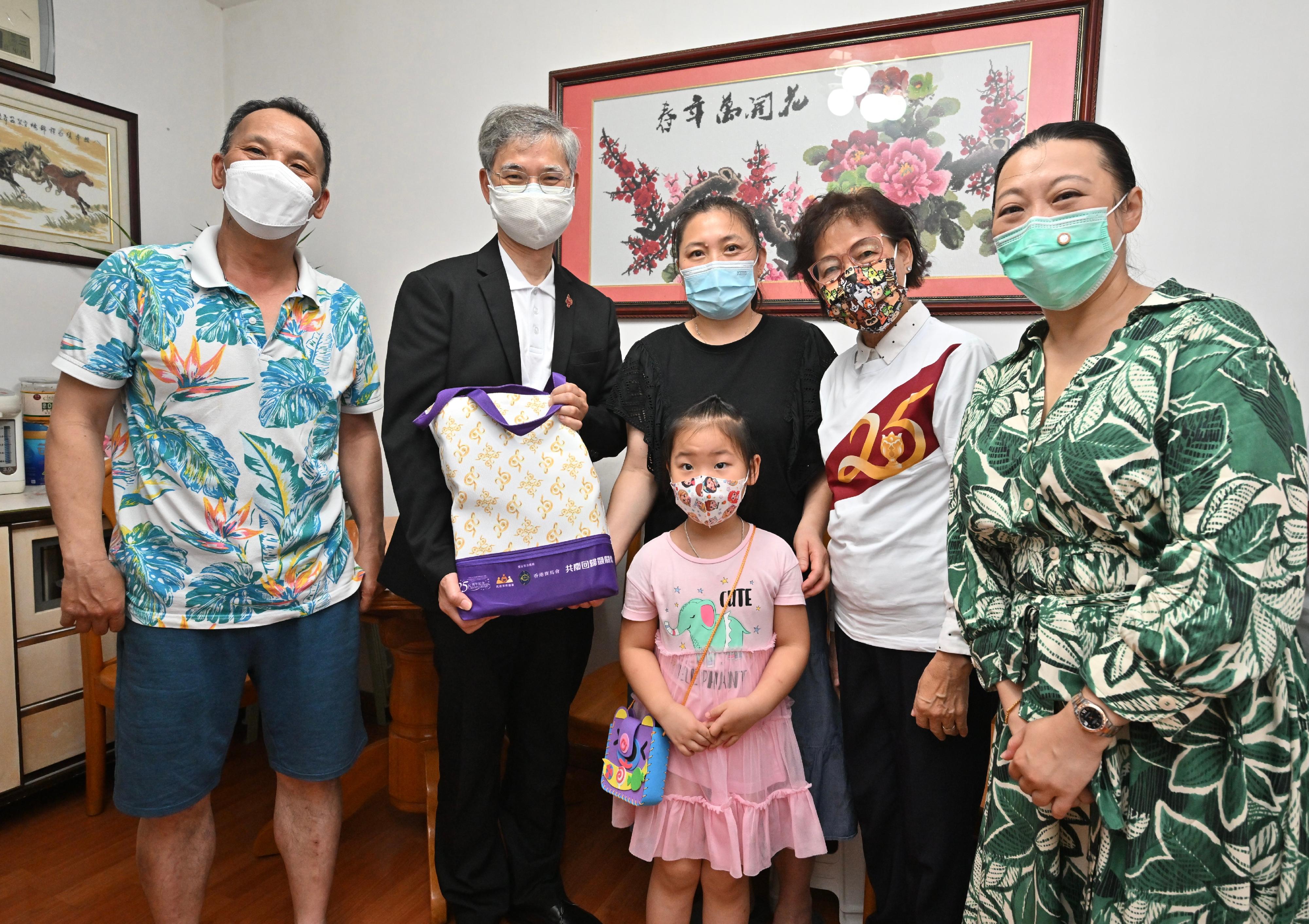 The Secretary for Labour and Welfare, Dr Law Chi-kwong, today (June 20) visited Wan Chai District and Islands District, and distributed gift packs under the Celebrations for All project in celebration of the 25th anniversary of the establishment of the Hong Kong Special Administrative Region, extending warm regards to the disadvantaged and the underprivileged. Photo shows Dr Law (second left), accompanied by the District Officer (Islands), Miss Amy Yeung (first right), and the Chairman of the OIWA, Ms Chau Chuen-heung (second right), in a visit to a grass-roots family in Tung Chung.