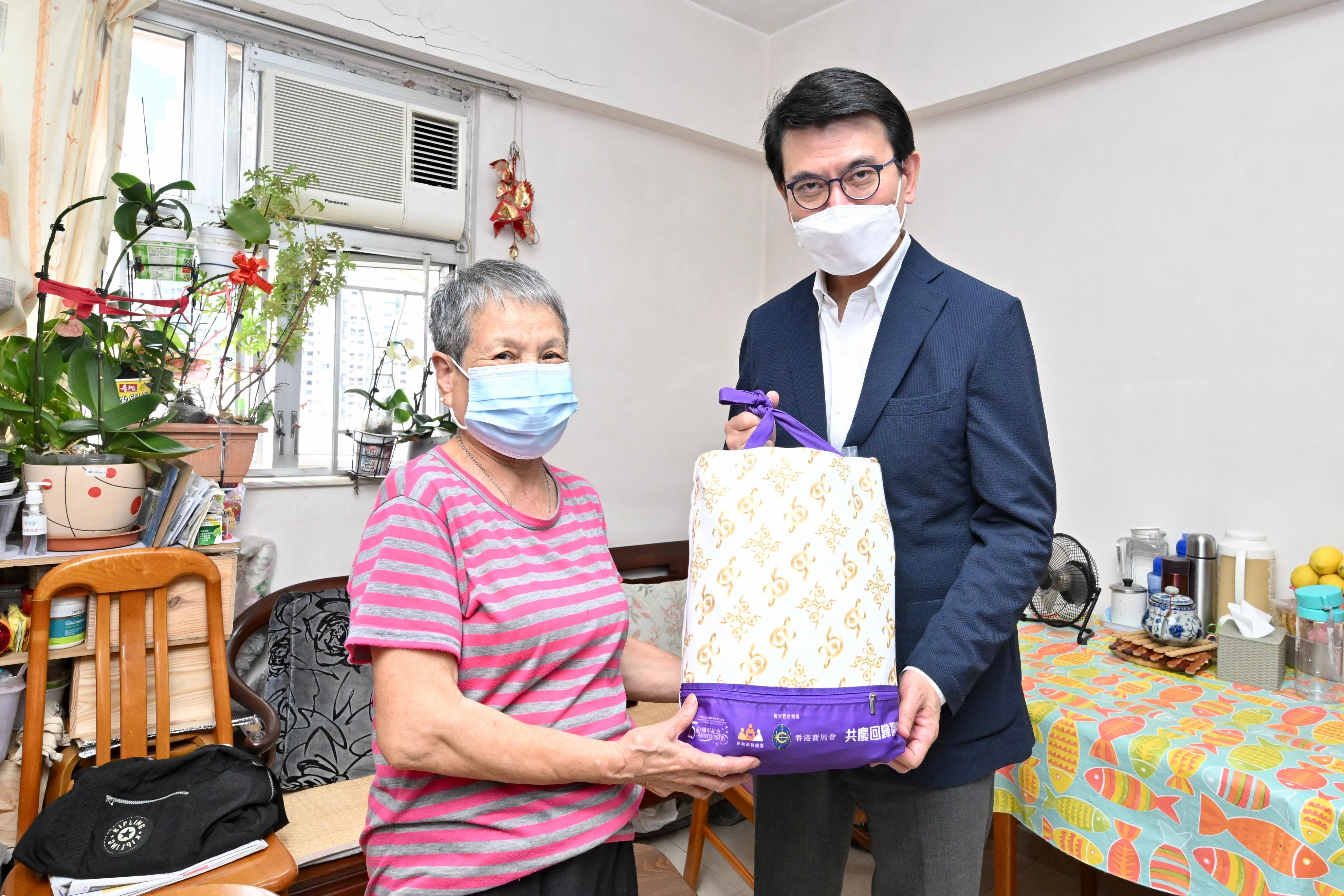 The Secretary for Commerce and Economic Development, Mr Edward Yau, paid home visits under the Celebrations for All project in Central and Western District today (June 21). Photo shows Mr Yau (right) visiting a single elderly person and giving her a gift pack in celebration of the 25th anniversary of the establishment of the Hong Kong Special Administrative Region.