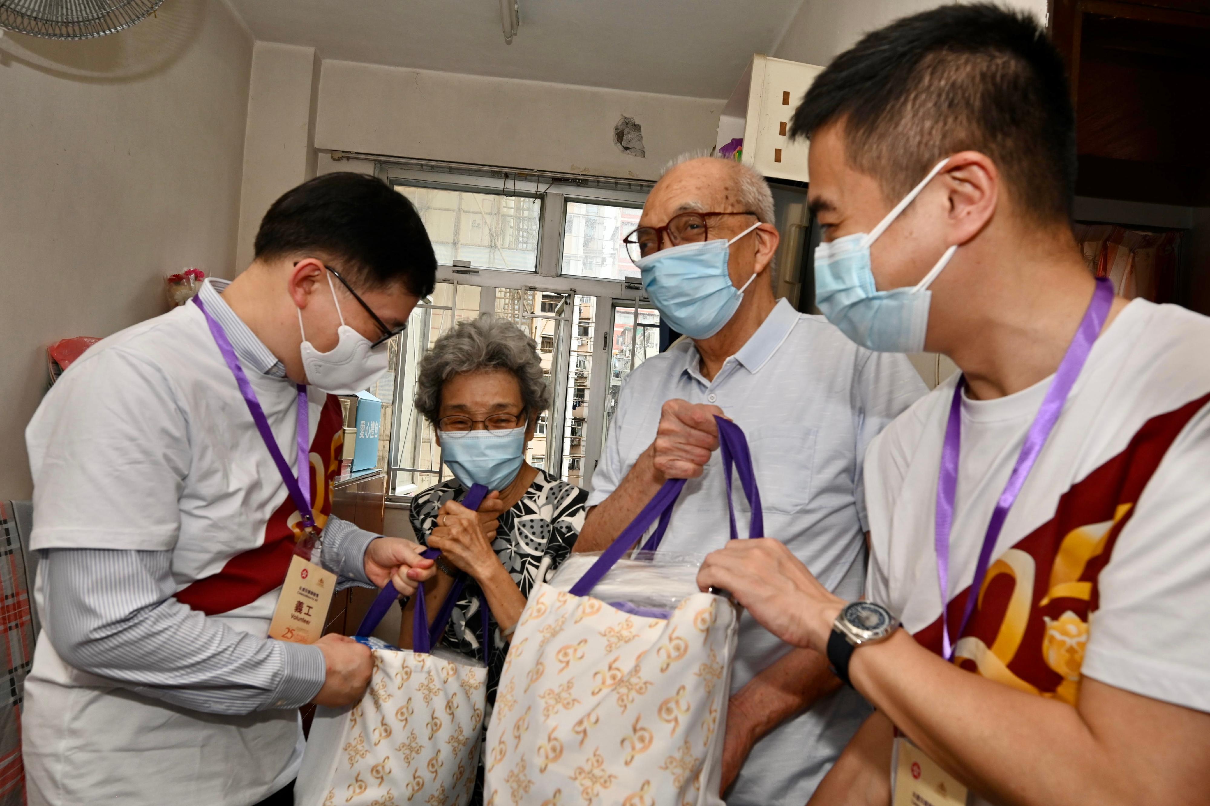The Under Secretary for Constitutional and Mainland Affairs, Mr Clement Woo, paid home visits under the Celebrations for All project in Yau Tsim Mong District today (June 21). Photo shows Mr Woo (first left), accompanied by the District Officer (Yau Tsim Mong), Mr Edward Yu (first right), visiting an elderly doubleton household and giving them gift packs in celebration of the 25th anniversary of the establishment of the Hong Kong Special Administrative Region.