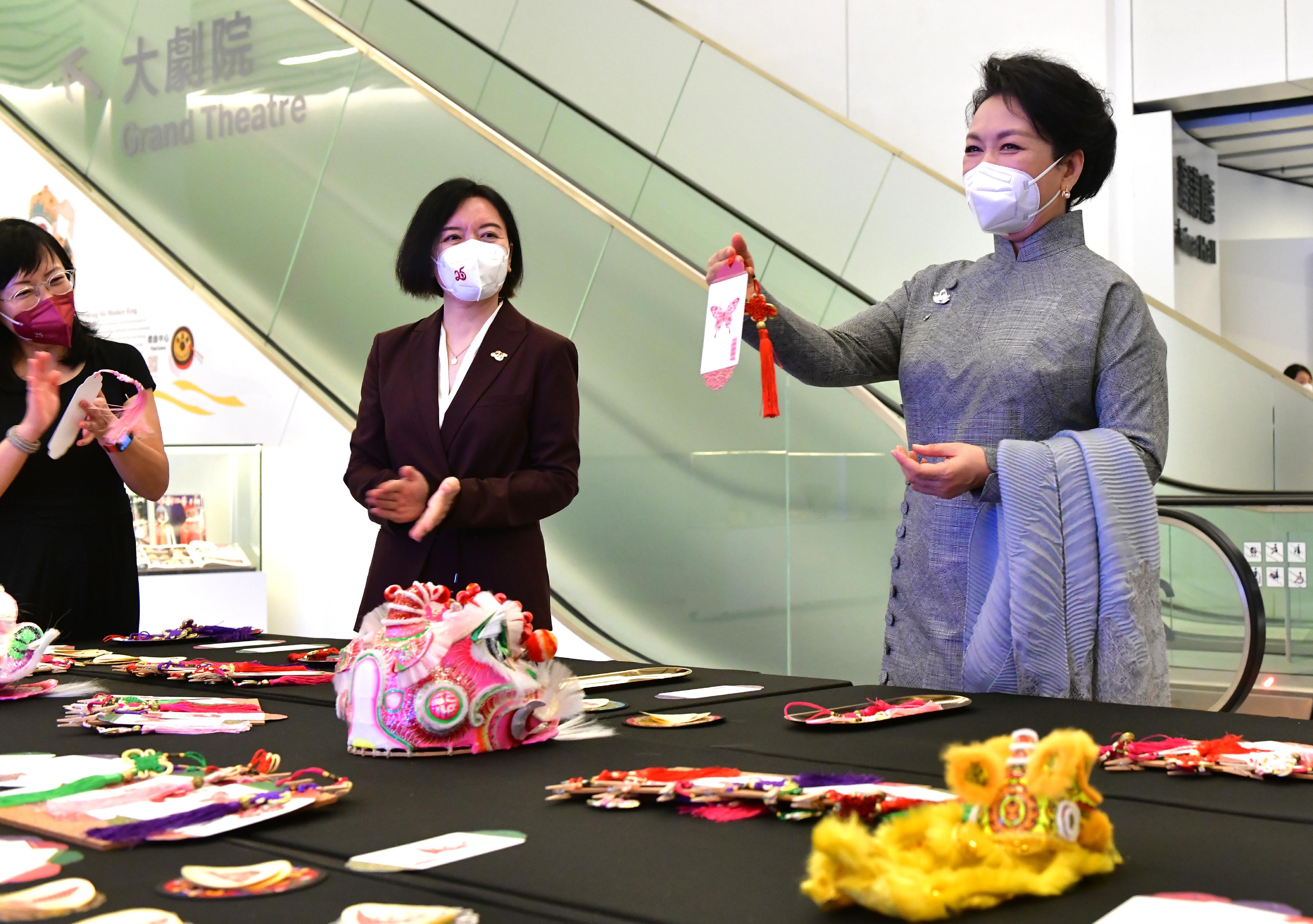 The wife of President Xi Jinping, Peng Liyuan, visited the Xiqu Centre of the West Kowloon Cultural District this afternoon (June 30). Photo shows Peng (right), accompanied by Deputy Director of the Liaison Office of the Central People's Government in the Hong Kong Special Administrative Region Ms Lu Xinning (centre) and Deputy Secretary for Home Affairs Ms Kinnie Wong (left), viewing handicrafts introducing world Intangible Cultural Heritage items.