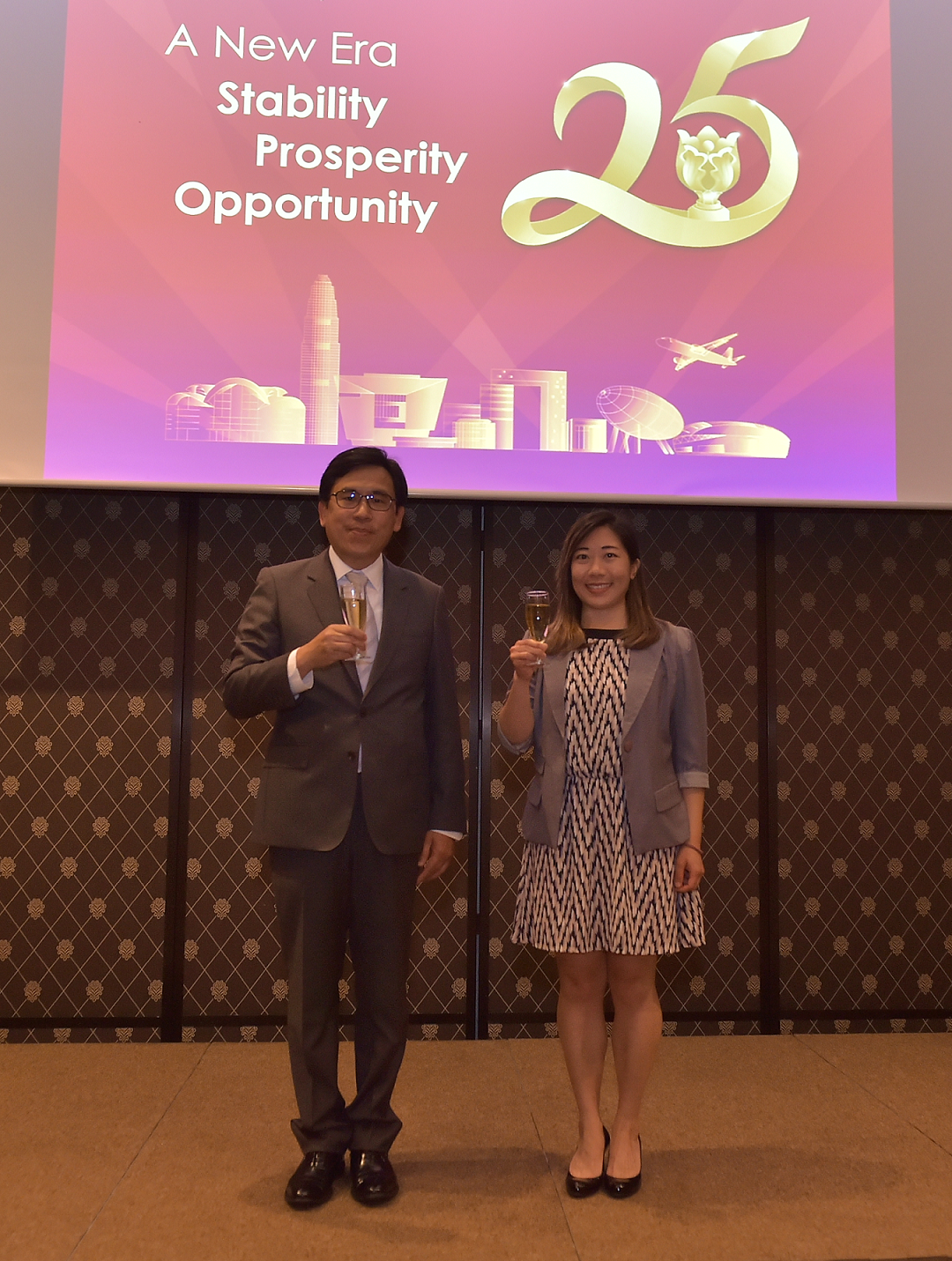 The Permanent Representative of the Hong Kong Special Administrative Region (HKSAR) of China to the WTO, Mr Laurie Lo (left), and the Director of the Hong Kong Economic and Trade Office, Berlin, Ms Jenny Szeto (right) toasted at the reception in Geneva celebrating the 25th anniversary of the establishment of the HKSAR on June 30 (Geneva time).