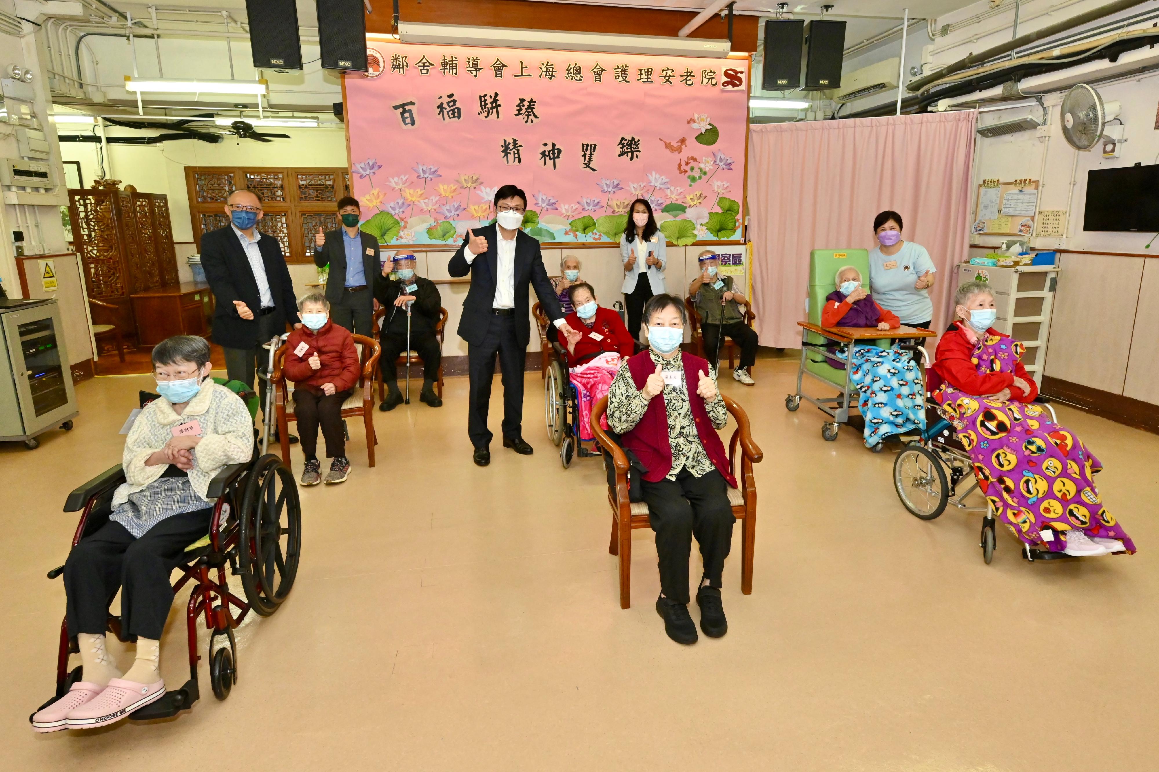 The Secretary for Labour and Welfare, Mr Chris Sun, today (July 5) inspected a COVID-19 vaccination day at a residential care home for the elderly in Ho Man Tin to take a closer look at the latest progress of outreach vaccination for residential care homes. Photo shows Mr Sun (second row, third left); the Executive Director of the Neighbourhood Advice-Action Council, Ms Fung Sau-man (third row, second right); and the Assistant Director of Social Welfare (Elderly), Mr Tan Tick-yee (second row, first left), with residents receiving vaccination today.