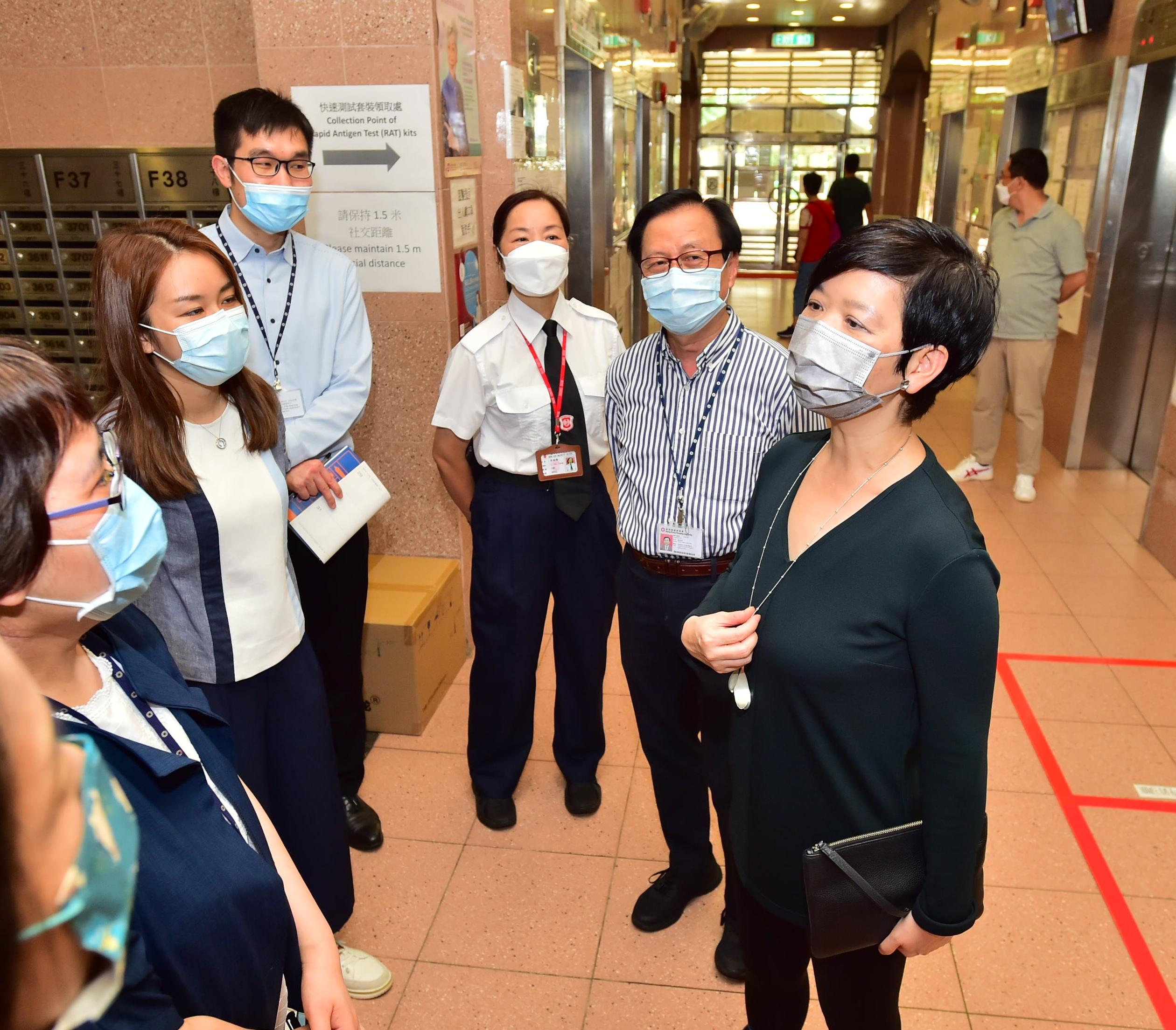The Secretary for Housing, Ms Winnie Ho, visited Tsz Ching Estate in Tsz Wan Shan this afternoon (July 7) to learn about the distribution arrangements of COVID-19 rapid antigen test (RAT) kits in public rental housing estates by the Housing Department. Photo shows Ms Ho (first right) being briefed by Tsz Ching Estate staff on the arrangement and workflow of the distribution of the RAT kits.