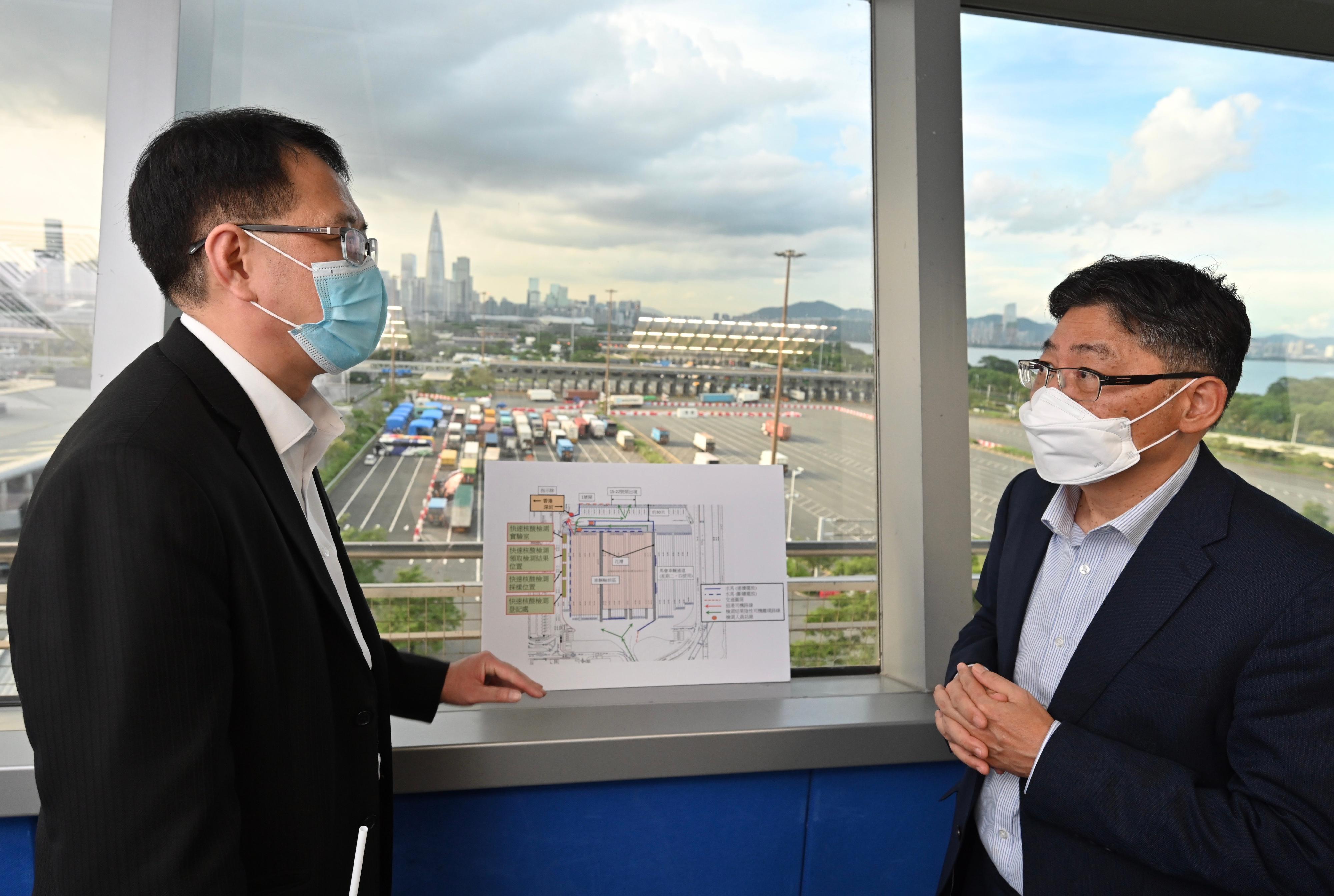 The Secretary for Transport and Logistics, Mr Lam Sai-hung, visited the Shenzhen Bay Port this afternoon (July 8) to inspect the operation of cross-boundary land transport of goods. Photo shows Mr Lam (right) being briefed by Principal Transport Officer (New Territories) of the Transport Department Mr Patrick Ng (left), on the current operation of cross boundary land transport of goods at the land boundary control points in Hong Kong.