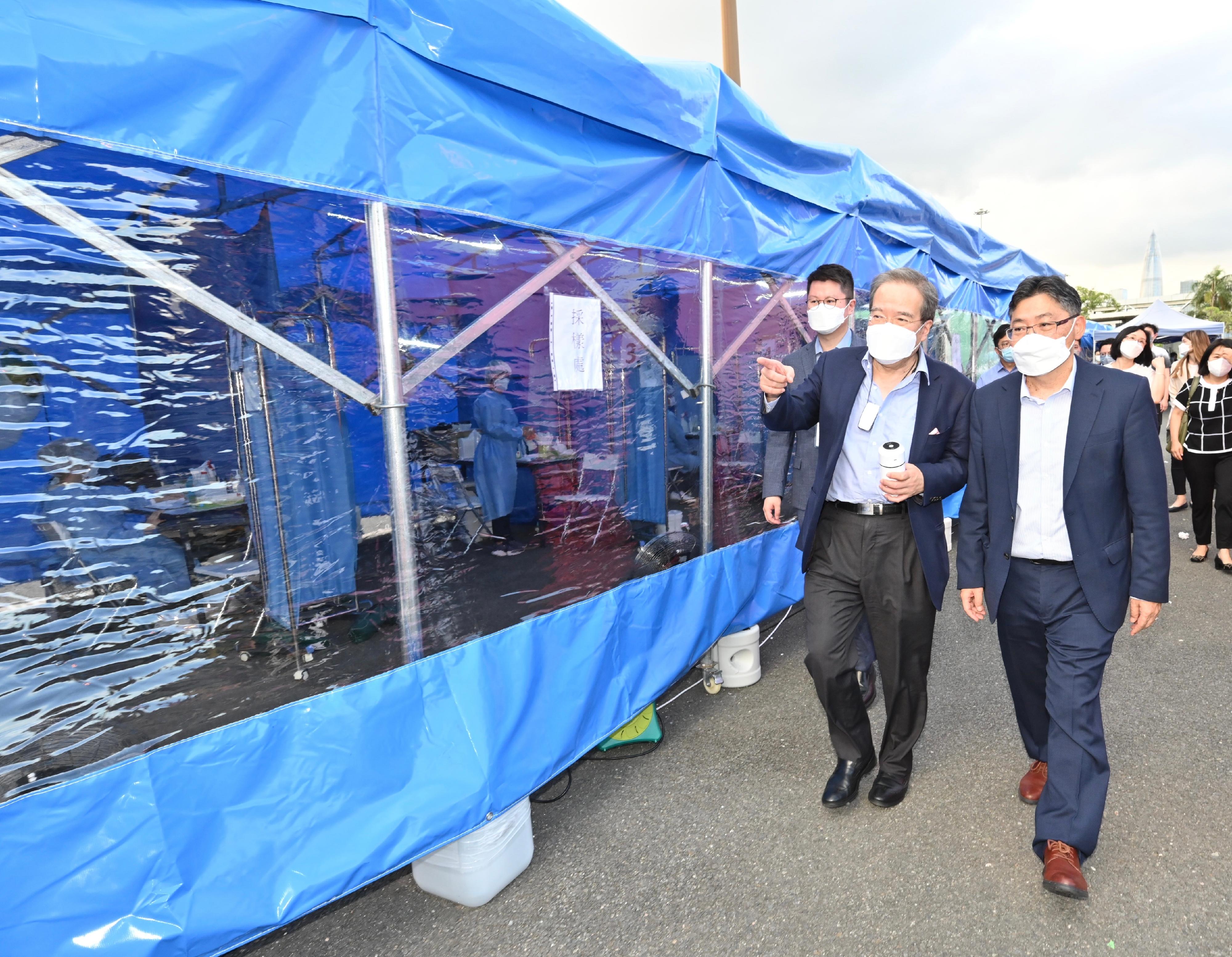 The Secretary for Transport and Logistics, Mr Lam Sai-hung (right), was briefed by a testing contractor's representative on the rapid nucleic acid testing arrangements at the Shenzhen Bay port today (July 8).