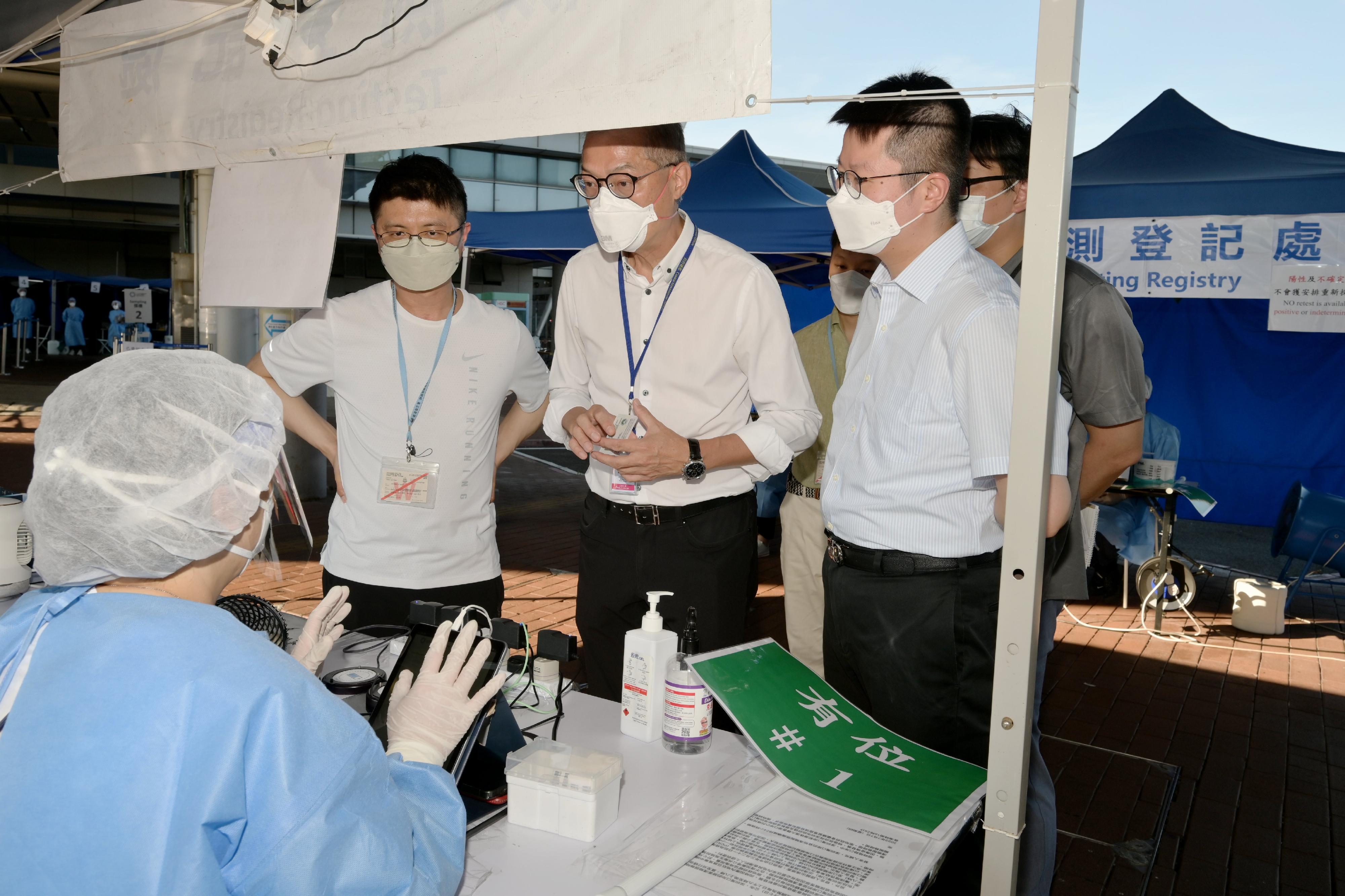 The Secretary for Health, Professor Lo Chung-mau (second left), went to the Shenzhen Bay Control Point today (July 10) to learn about the workflow for special nucleic acid testing before departure from frontline staff in the company of the Chief Port Health Officer of the Centre for Health Protection of the Department of Health, Dr Leung Yiu-hong (first left).